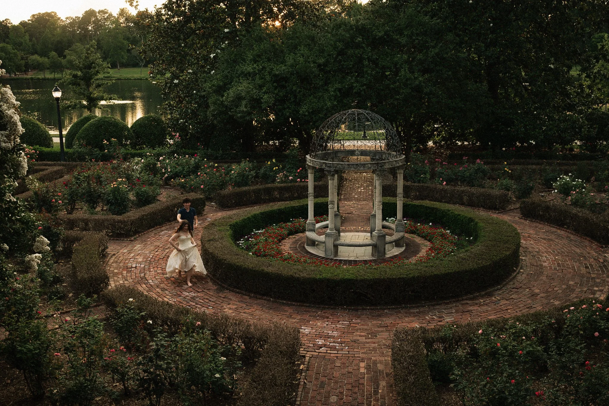 Couple runs around the rose garden at Furman University Greenville, SC at sunset.