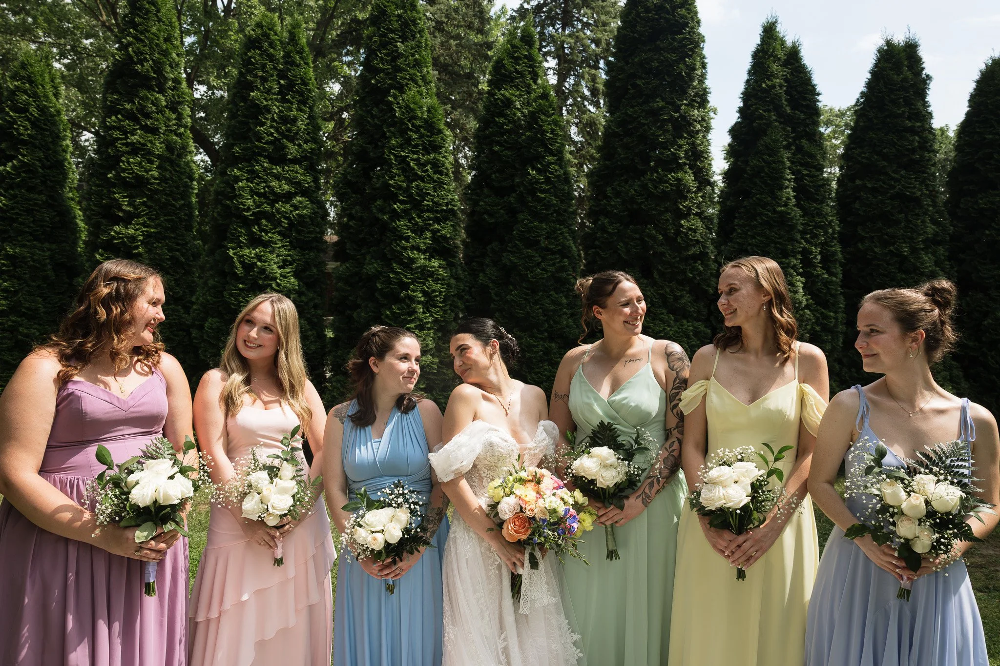 A bride and her friends pose in full sunlight with flash for a group photo.