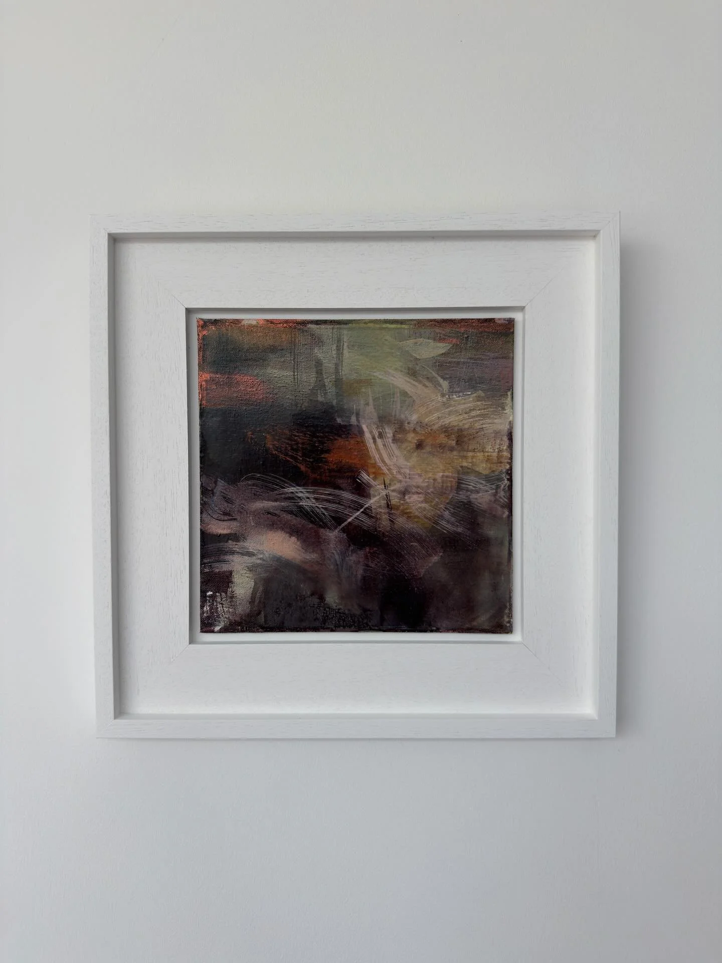 Soft strokes and loose marks sweep across the surface like petals caught in shifting light. Hints of blush pink, mossy green and muted copper flicker through the darker tones, giving the piece a sense of movement like wildflowers appearing and disapp