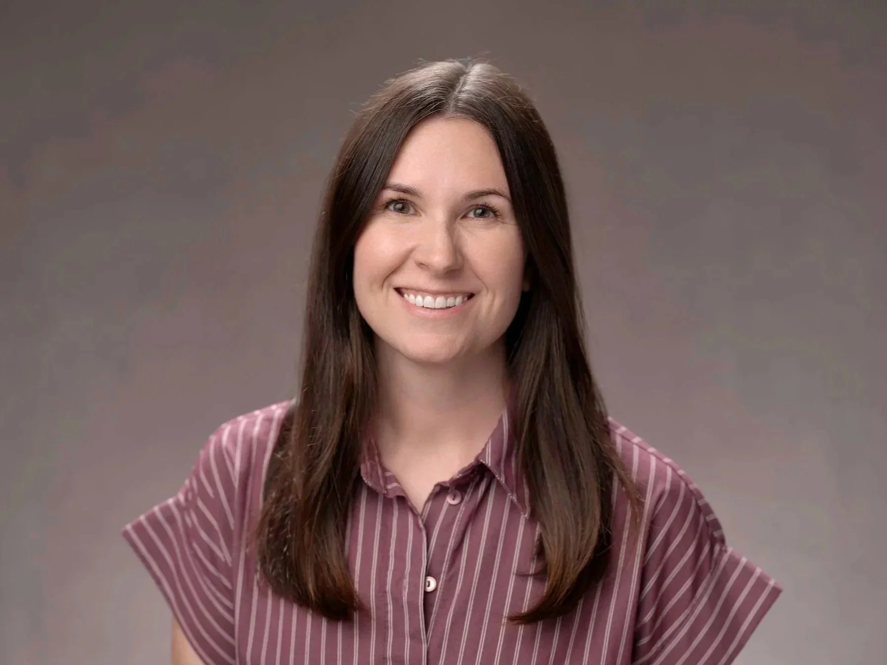Female child therapist with brown hair in San Diego, CA smiling