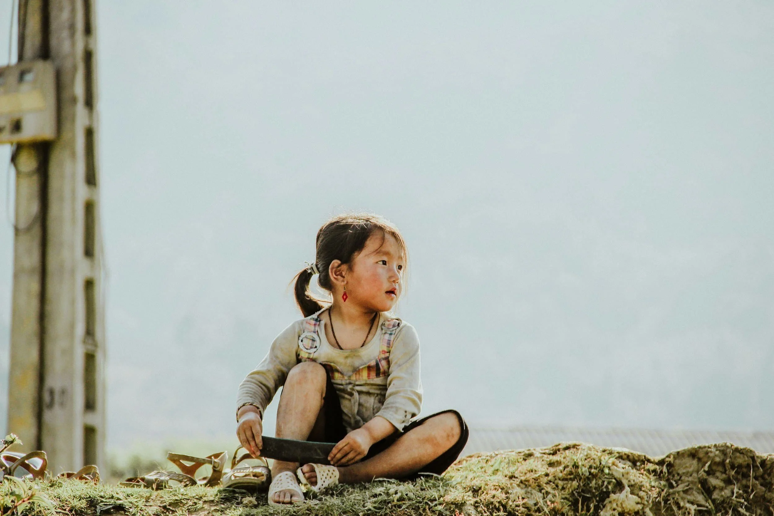 child sitting while playing in the dirt