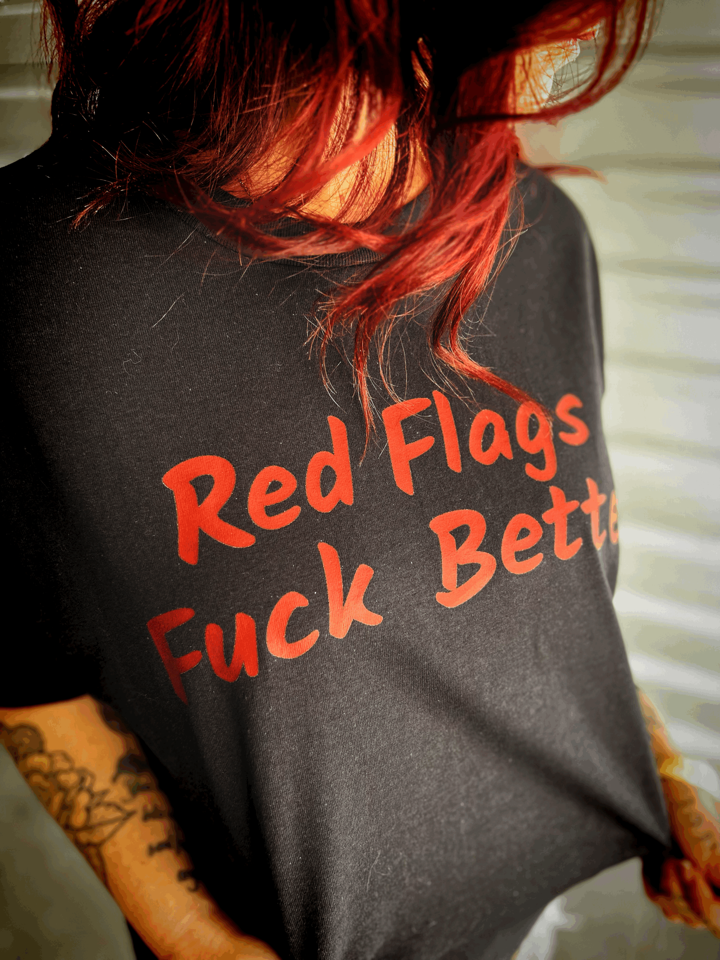 "Red Flags Fuck Better" men's heavyweight tee in black with deep red font.  Part of the Red Flag Fan Club Collection by The Bitter Bitch Co.
