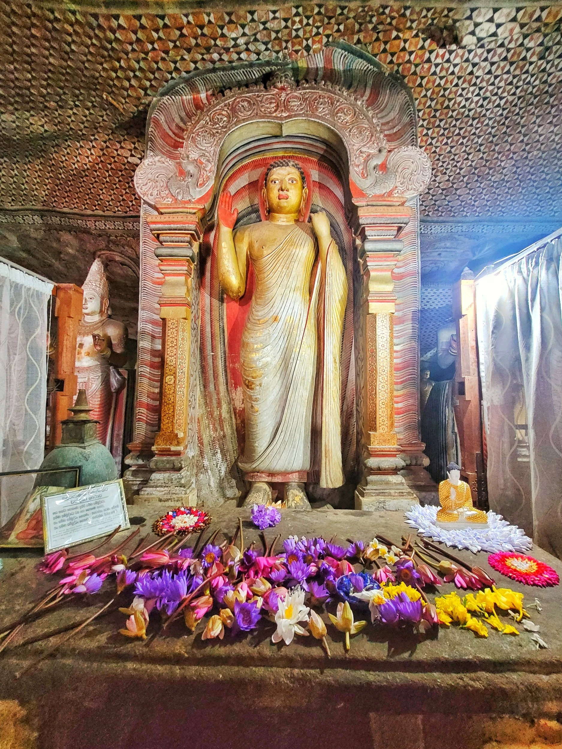Buddha-Statue mit Blumen als Opfergaben