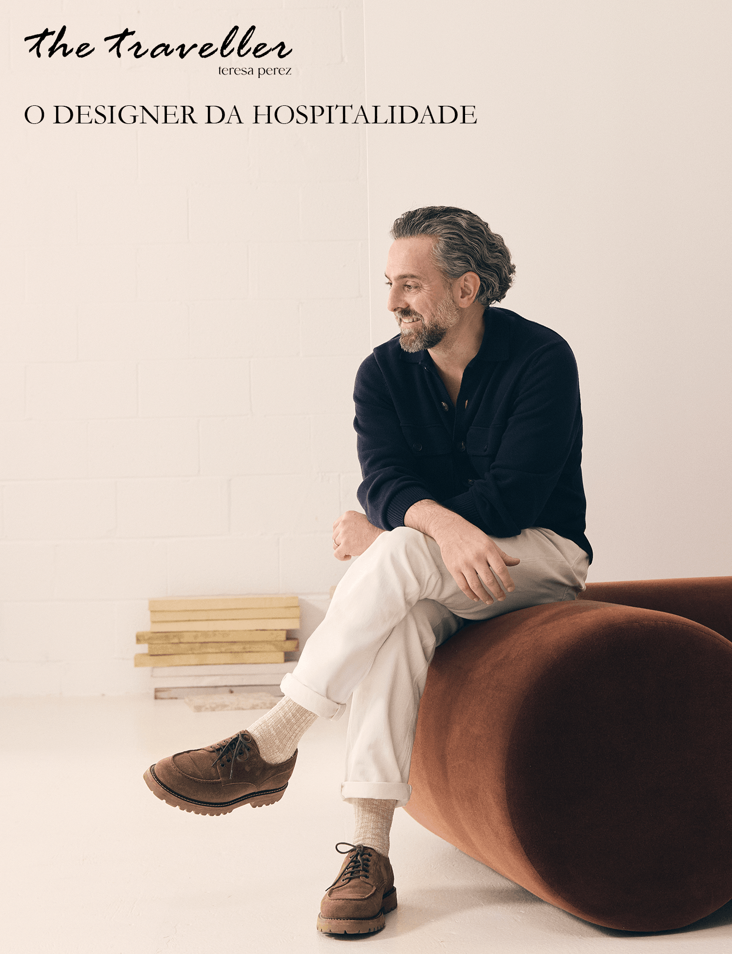 Paolo Ferrari seated on a sculptural brown sofa in a light-toned interior.