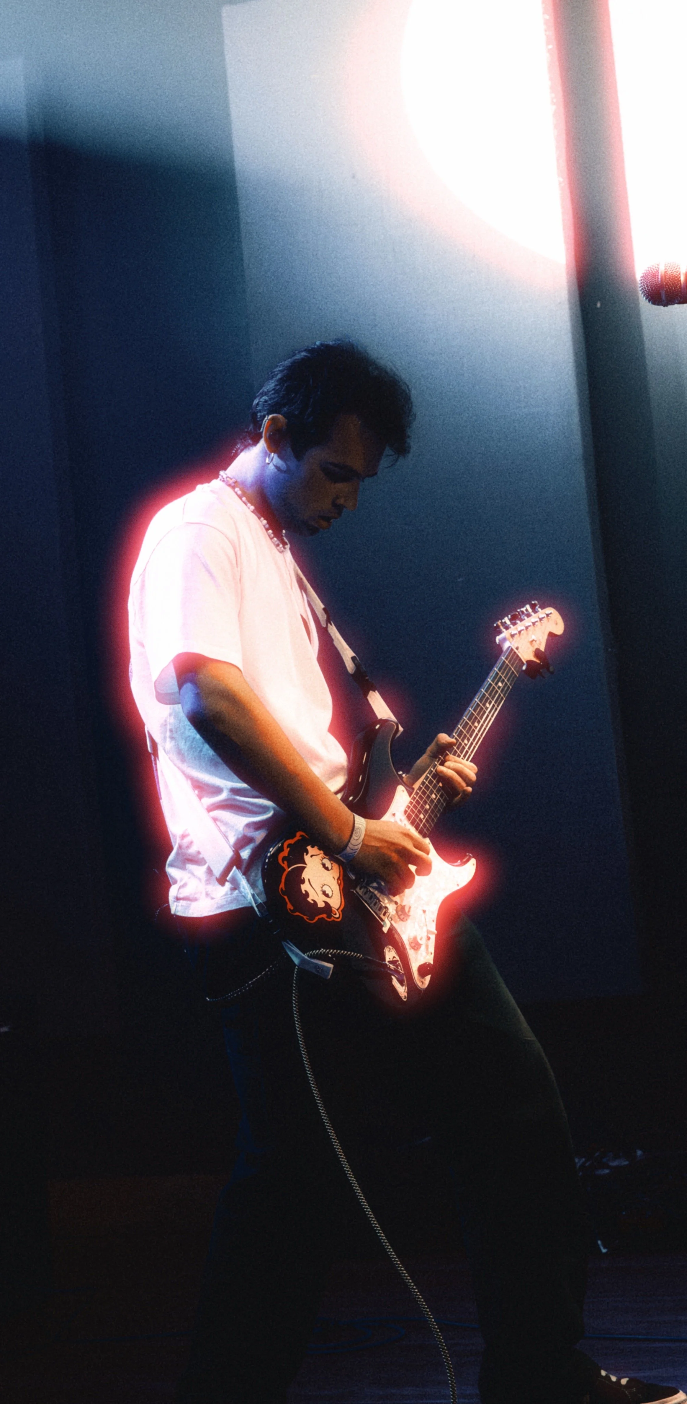 Brett Ryder on stage with electric guitar and Betty Boop sticker from 1980