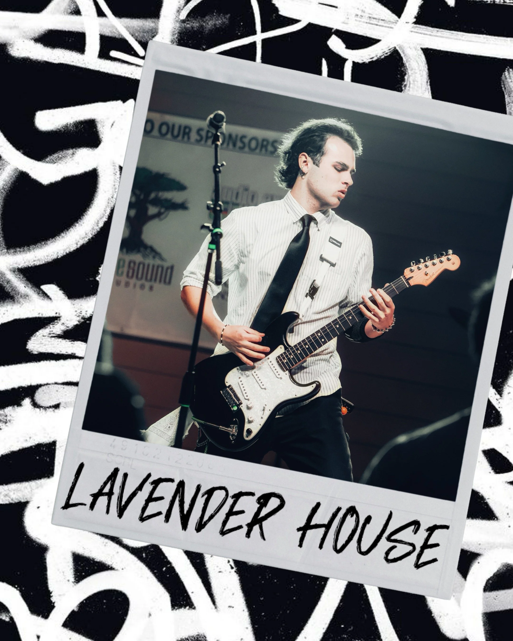 A black and white graffiti background with a Polaroid-style photo layered on top. The photo shows a young man playing an electric guitar on stage, wearing a striped shirt, black tie, and earrings, with a microphone stand nearby. The bottom part of the layered photo displays handwritten text that reads "LAVENDER HOUSE." There is also a partially visible banner in the background with the words "OUR SPONSORS."