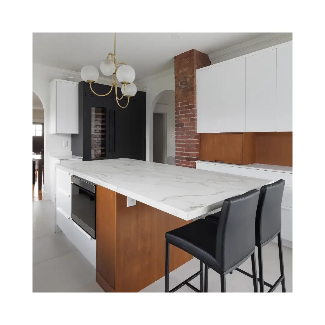 A modern kitchen featuring elegant marble countertops and sleek black stools for seating.