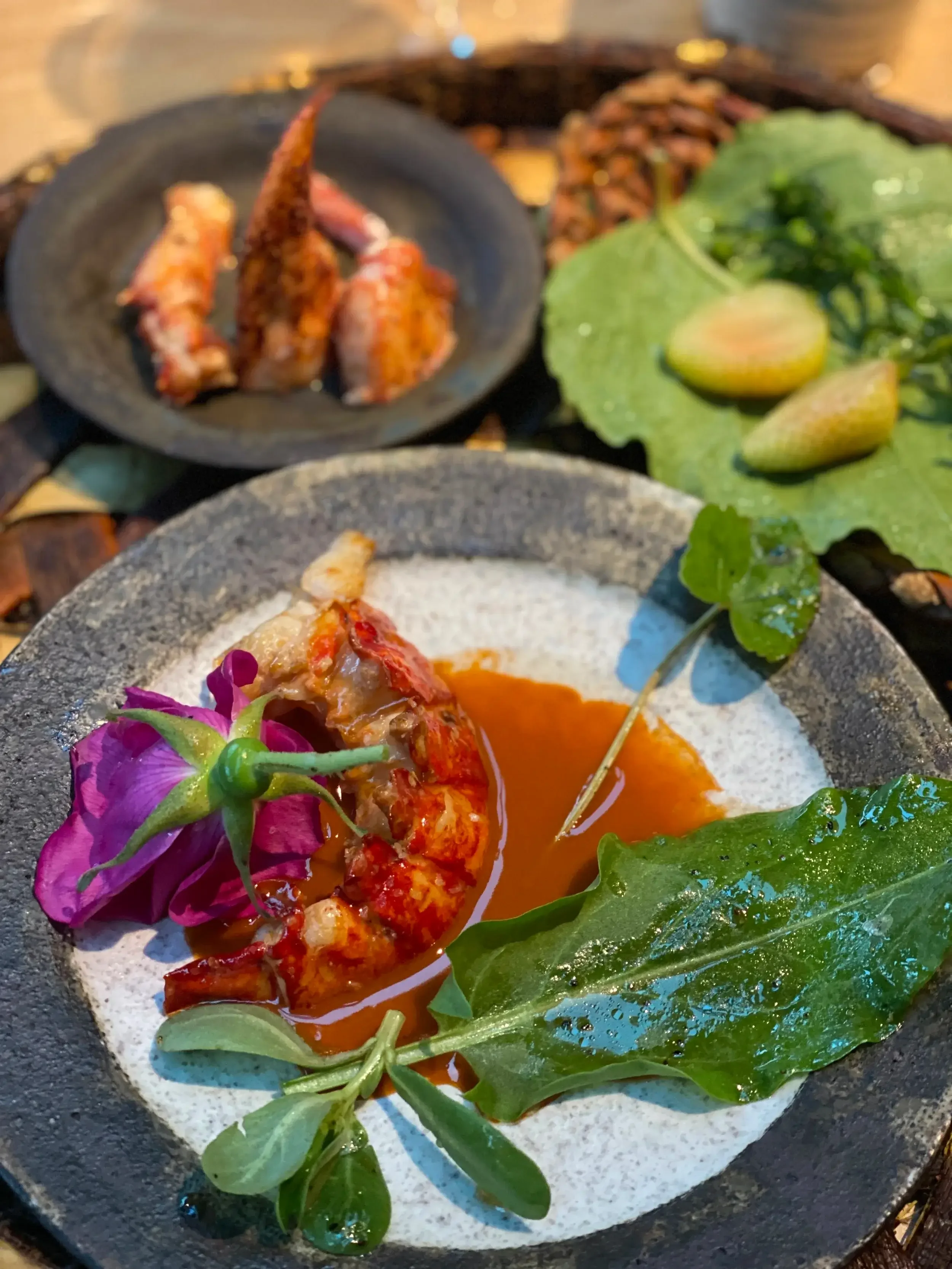 A plate featuring a beautifully arranged shrimp dish garnished with herbs and served with a lemon wedge.