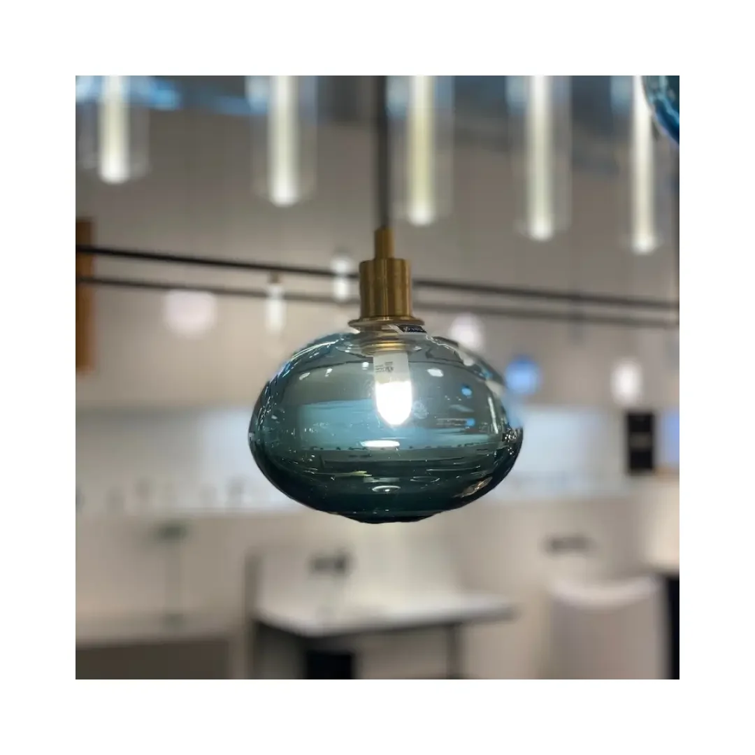 A blue glass pendant light elegantly suspended from the ceiling, casting a soft glow in the surrounding area.