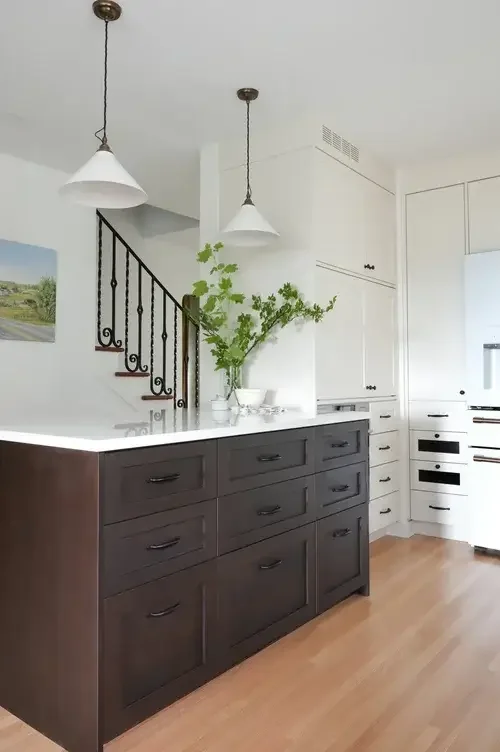 A spacious kitchen featuring a large island and warm wooden floors, creating a welcoming atmosphere for cooking and gathering