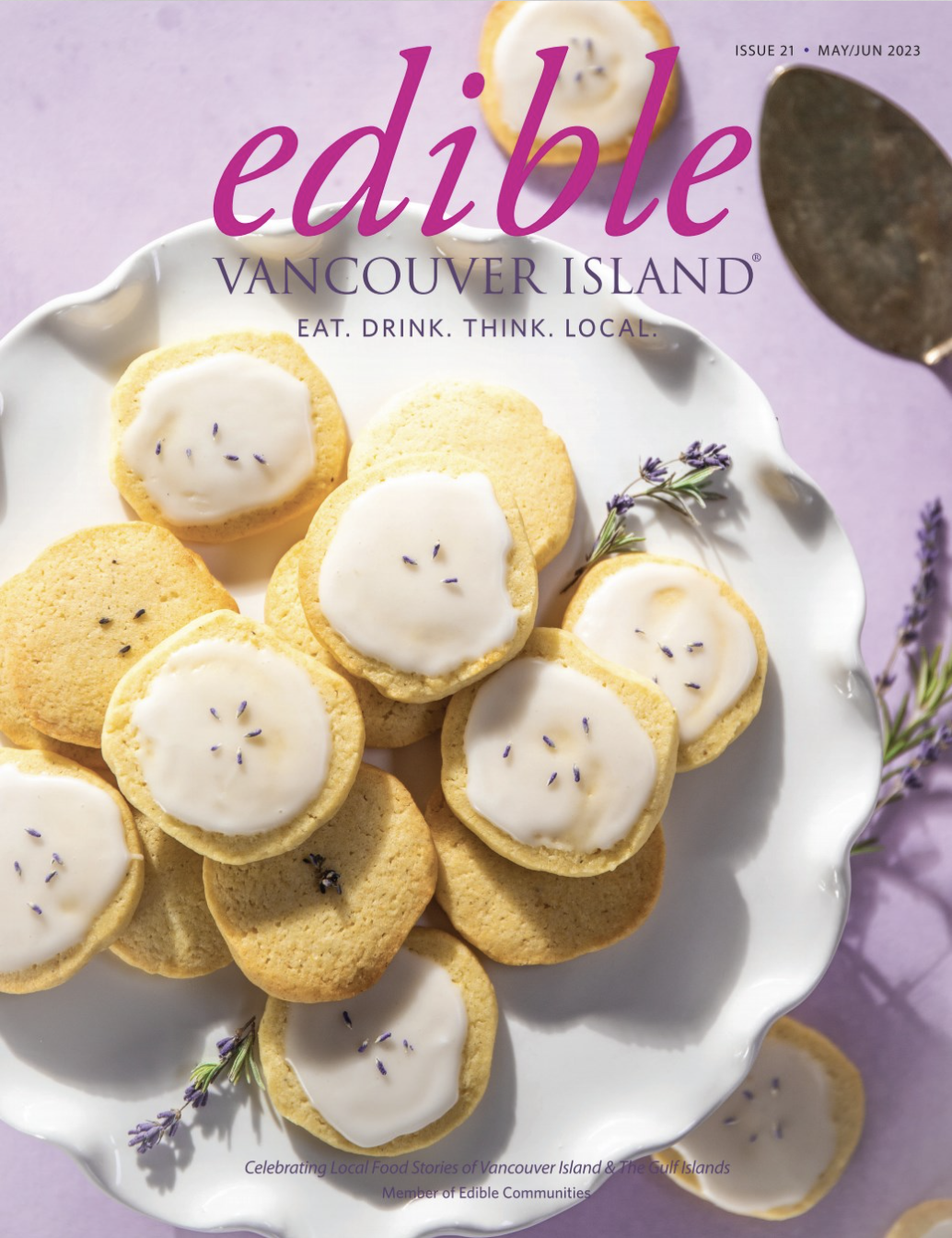 A magazine cover featuring a plate of cookies topped with white icing and small purple sprigs, with lavender flowers around the plate. The magazine is titled 'Edible Vancouver Island'.