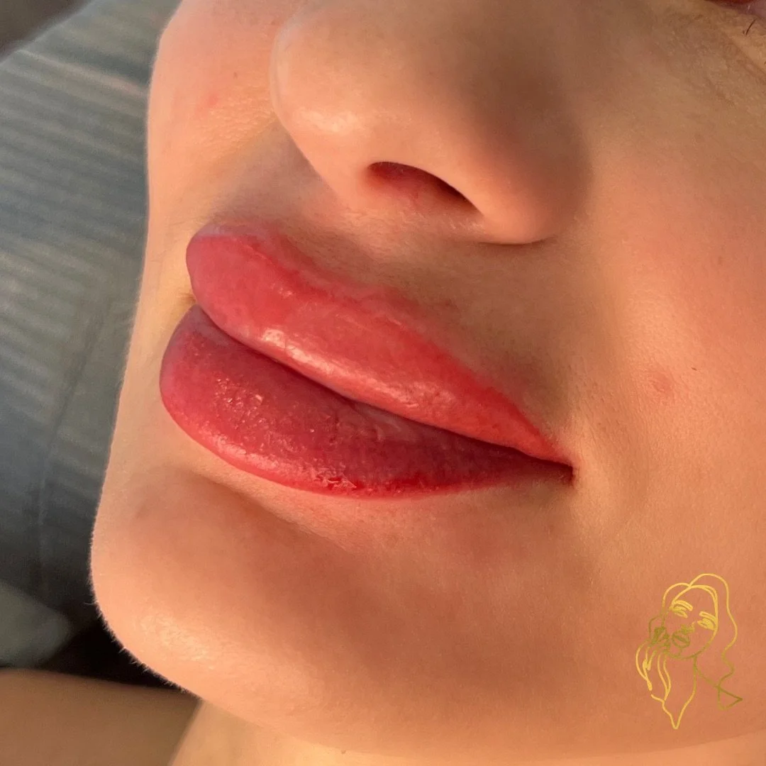 Close-up of a person's lips with pink lipstick and a small portion of their nose visible.