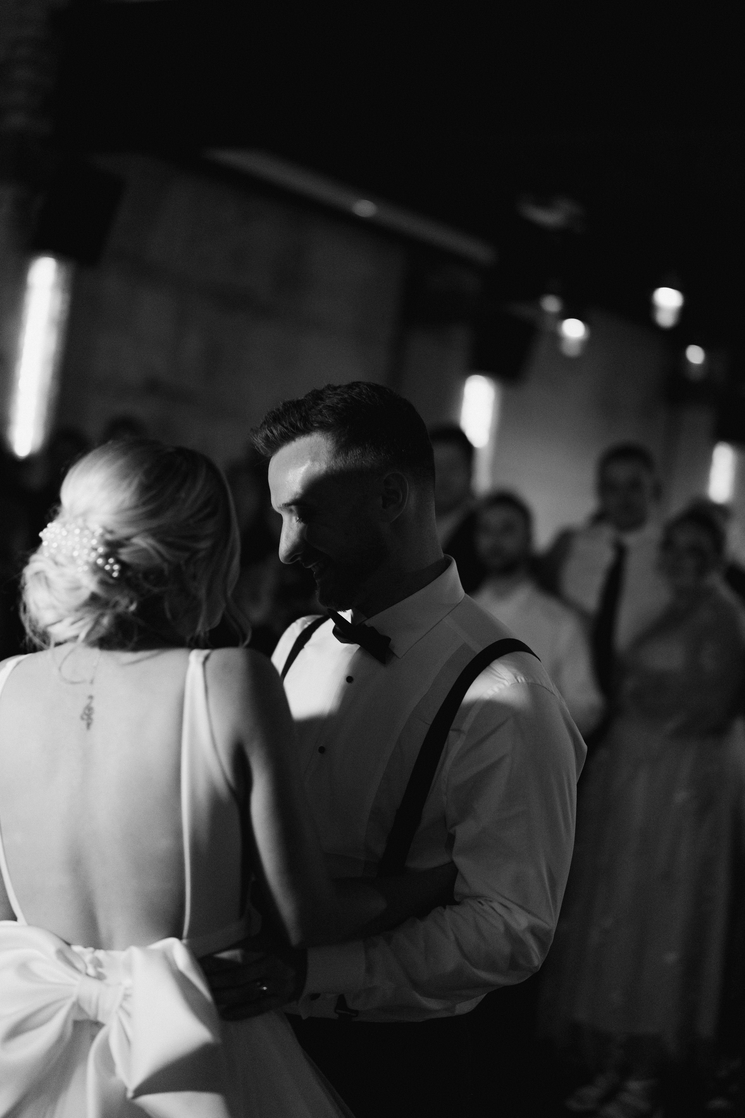 Bride and groom dancing at wedding reception, black and white photo