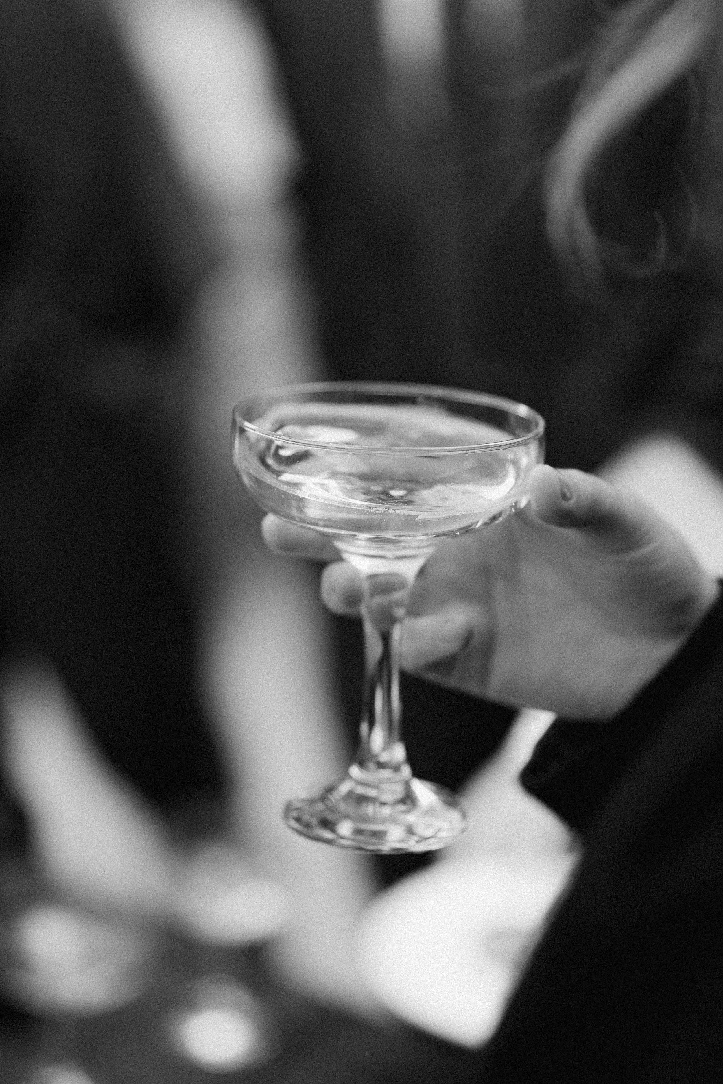 hand holding glass coupe with liquid