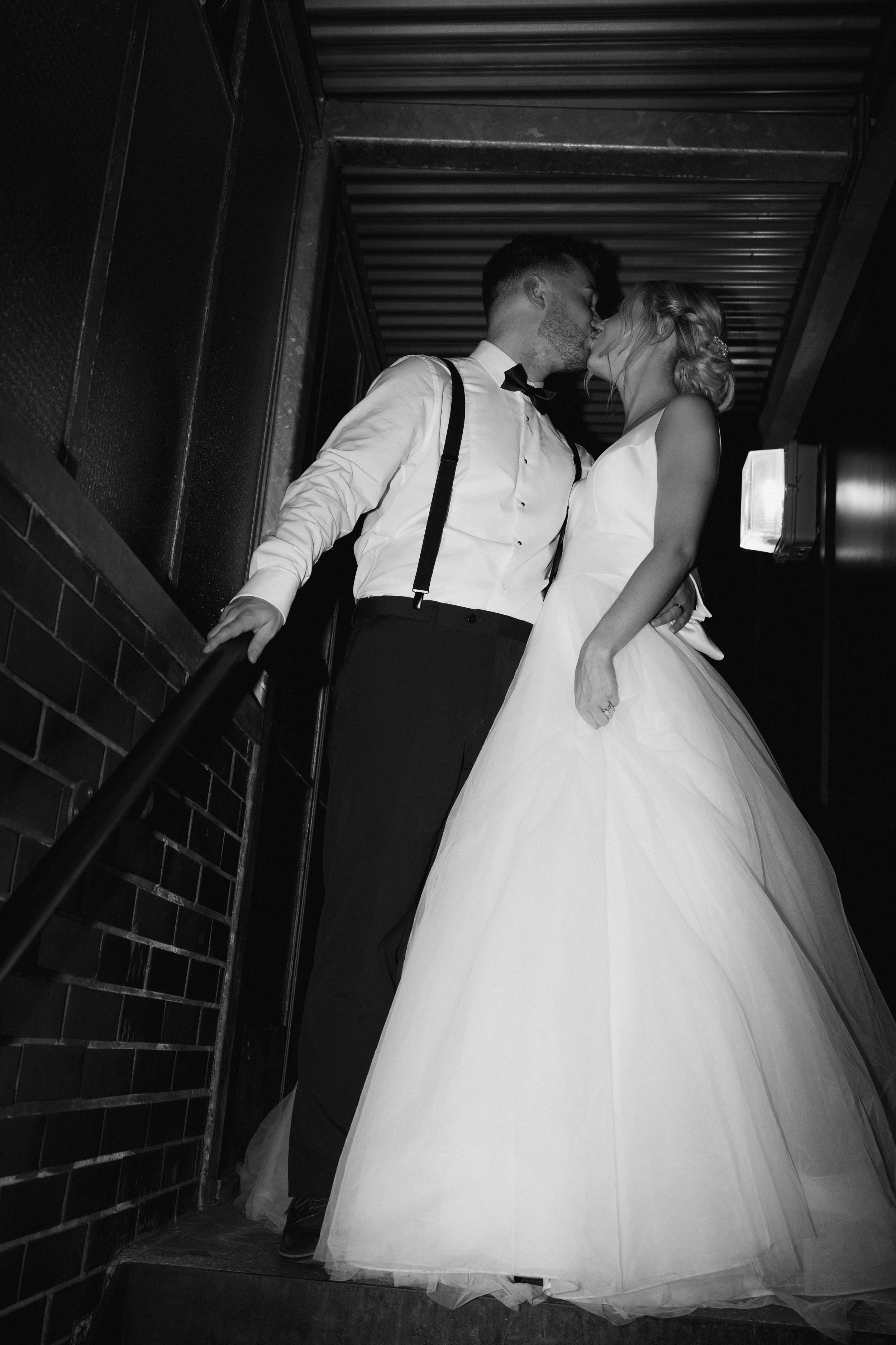 Bride and groom kissing in black and white photo
