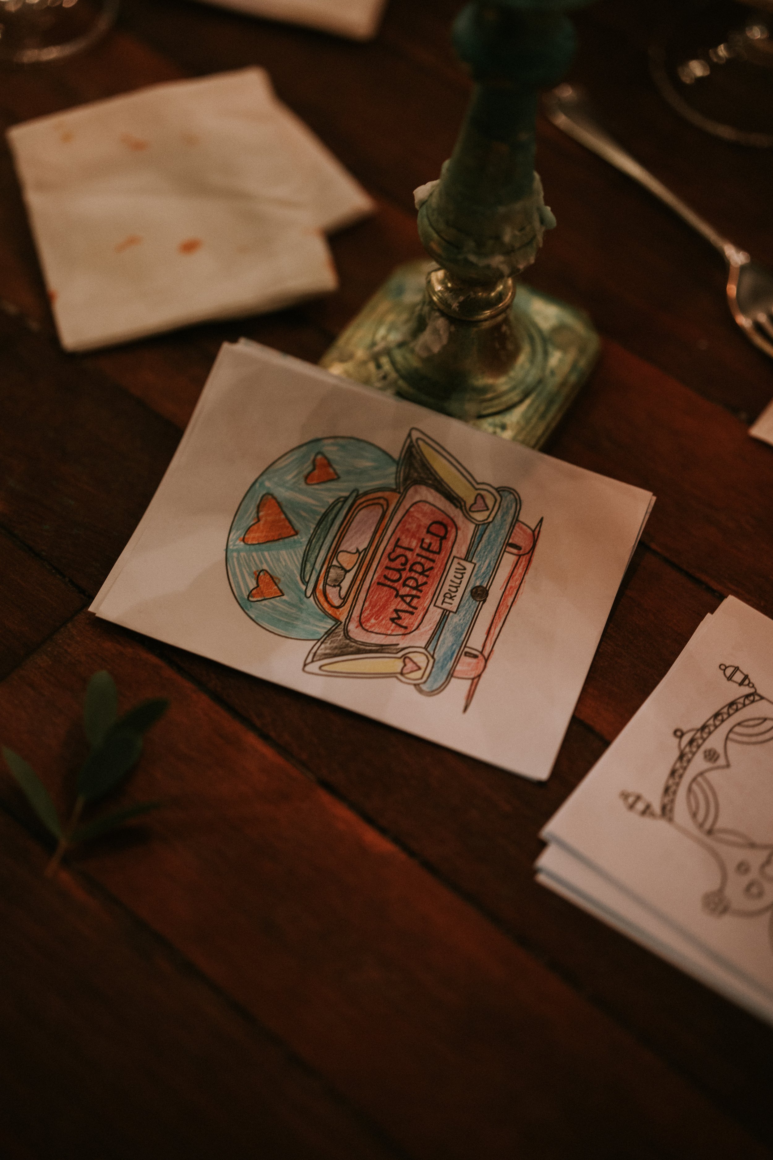 "Just Married" drawing on paper, vintage candlestick, napkins on wooden table.