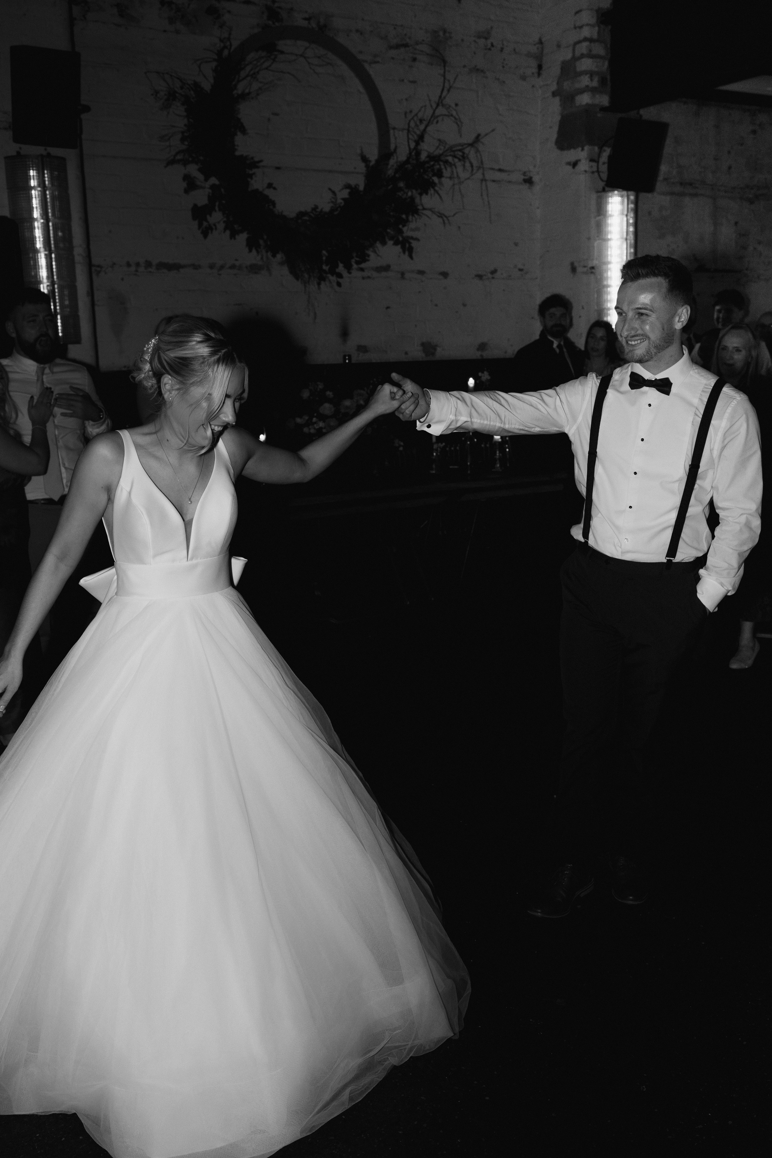 Bride and groom dancing at their wedding reception in black and white.