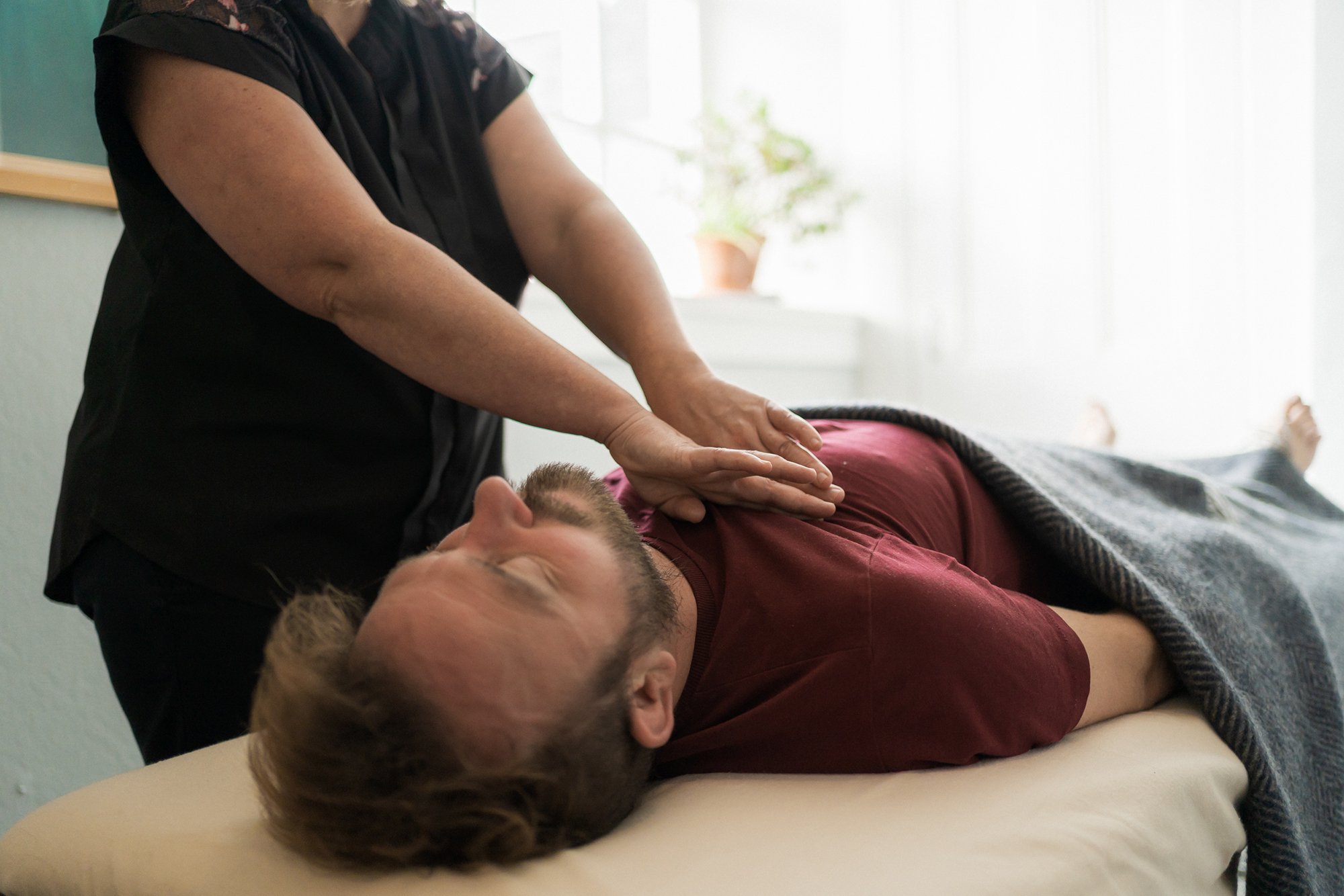 Man lying on back receiving chest treatment