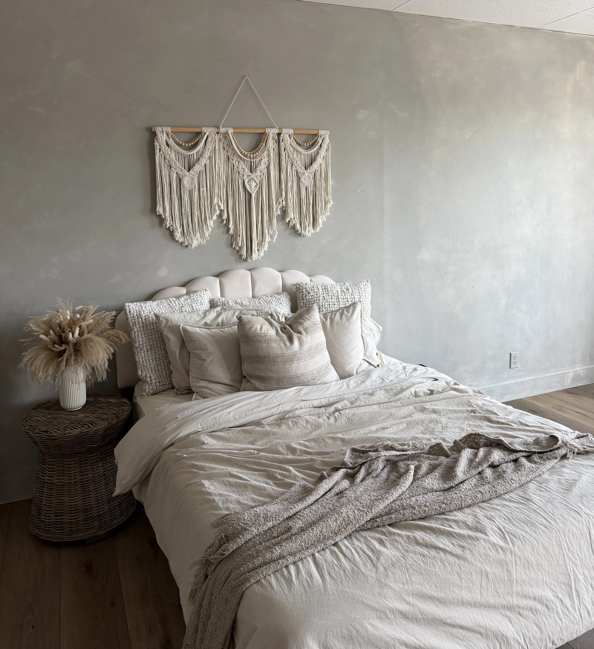 bed in natural light studio with stone washed wall