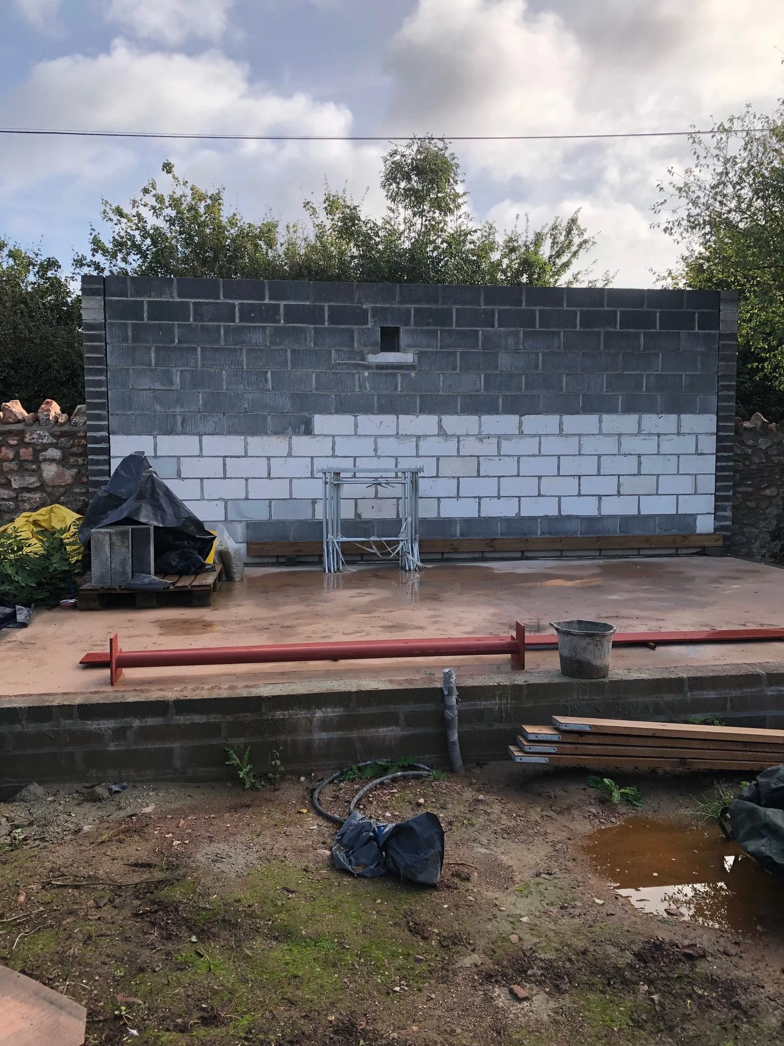 The newly built block wall shown from inside the property grounds, with newly laid foundations for the studio