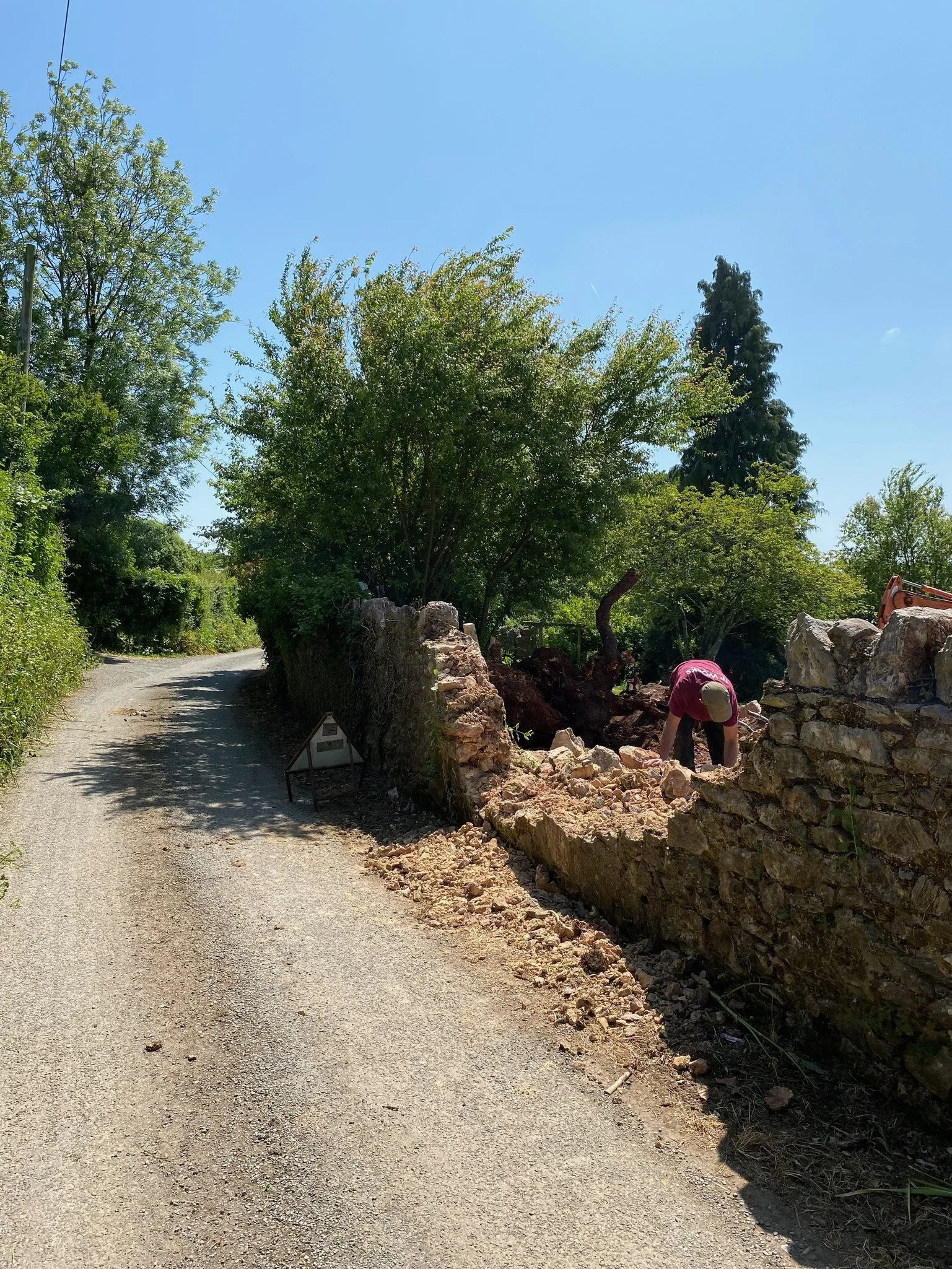 A traditional stone wall with damaged section removed for repairs