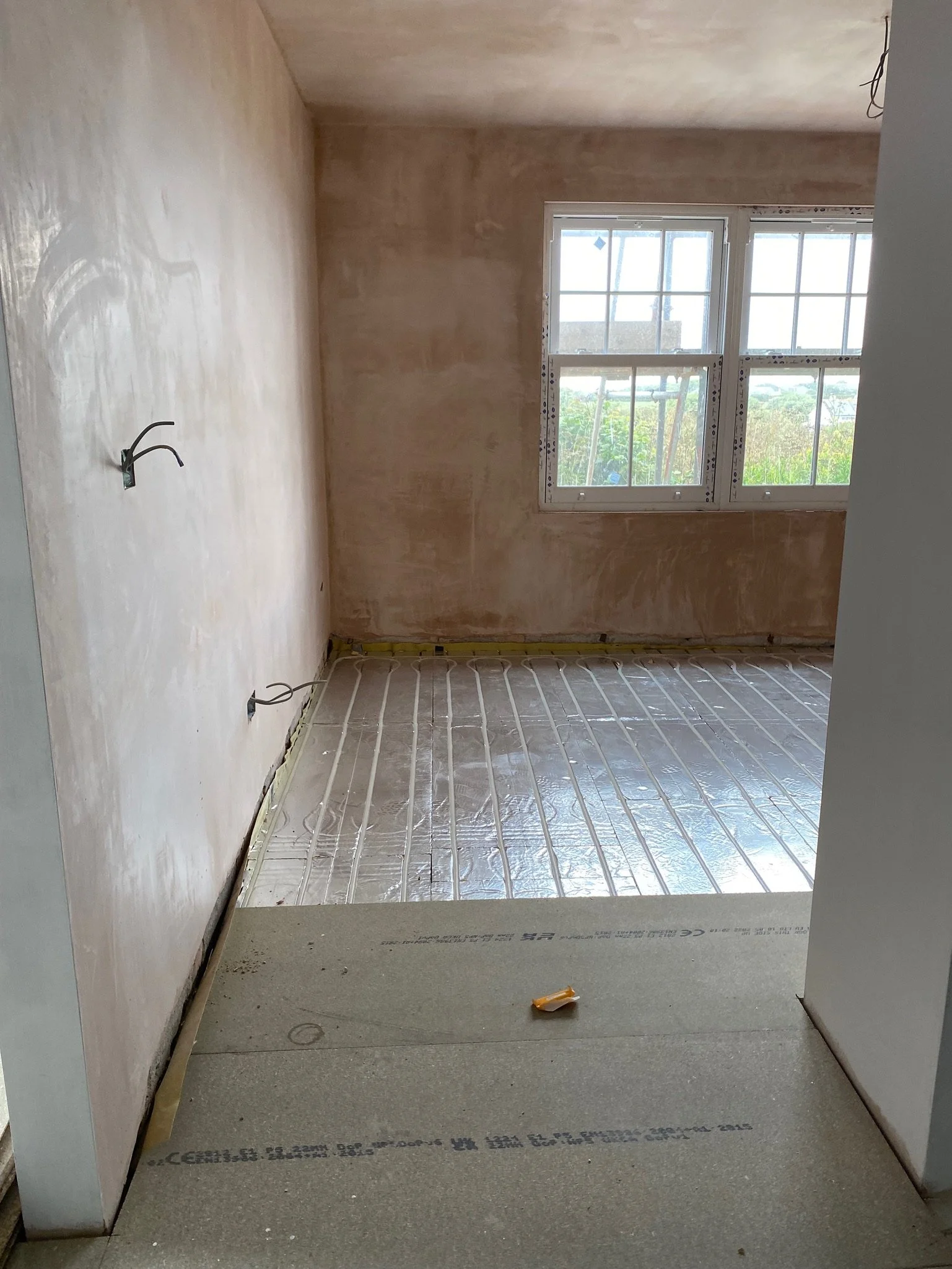 A newly plastered room with underfloor heating laid