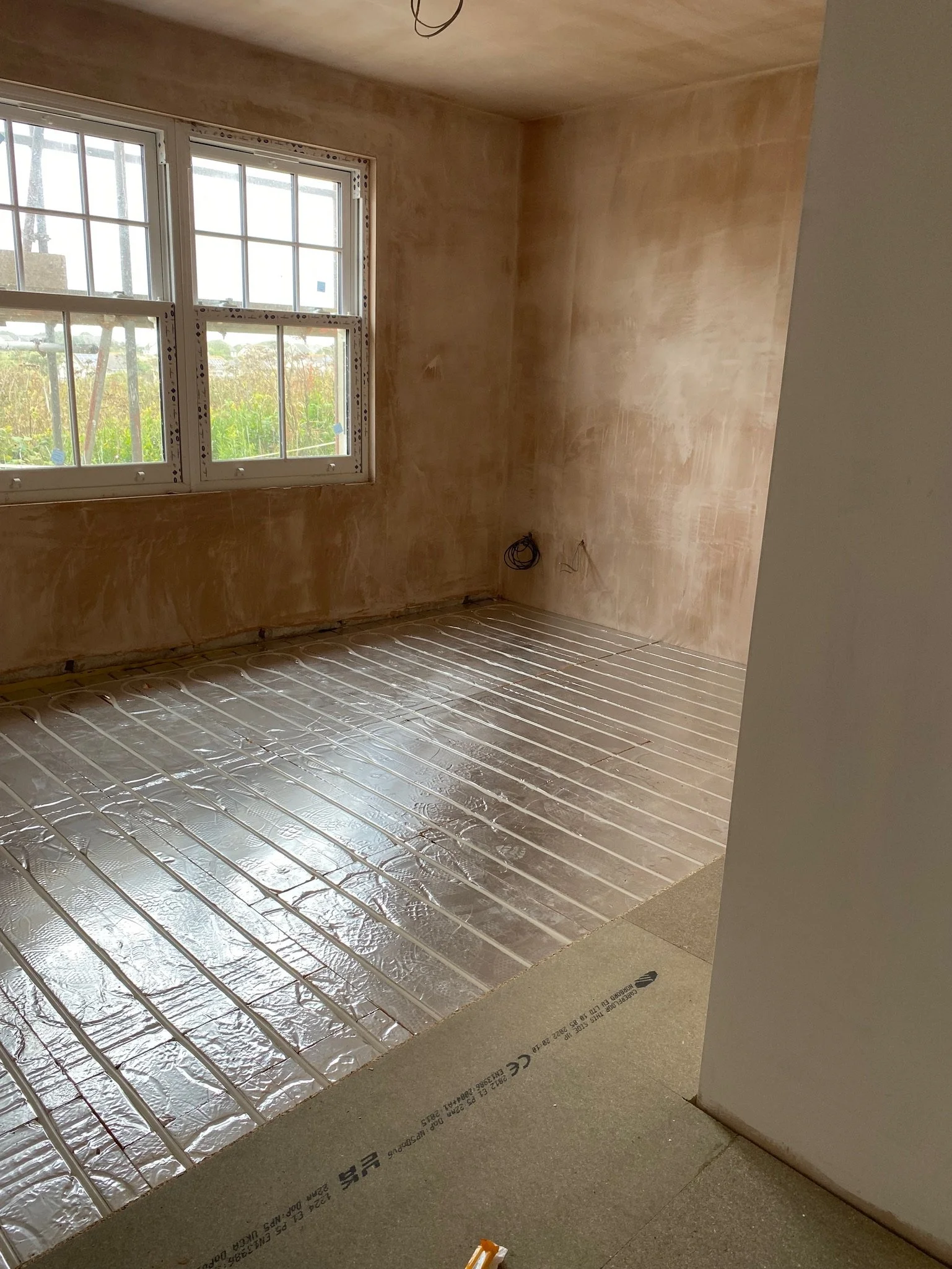 Another view of a room with new underfloor heating and plastering