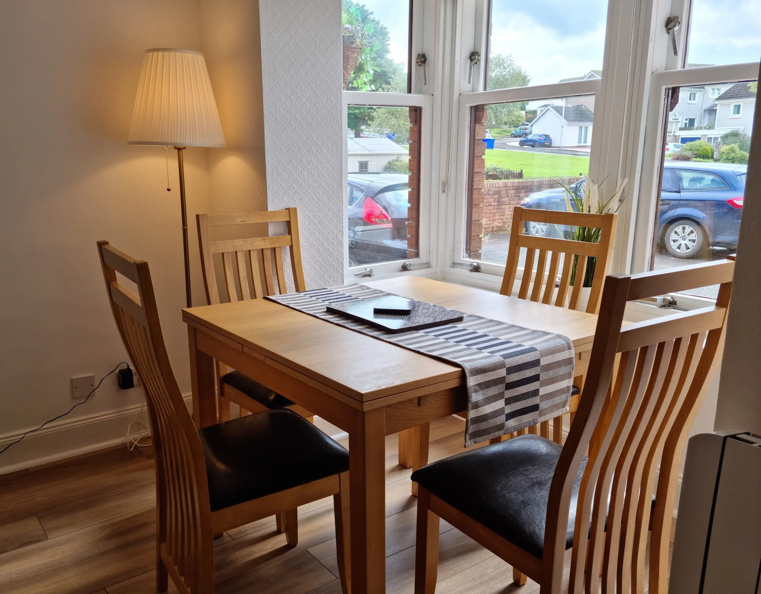 Front window of living room with dining table for 4 people