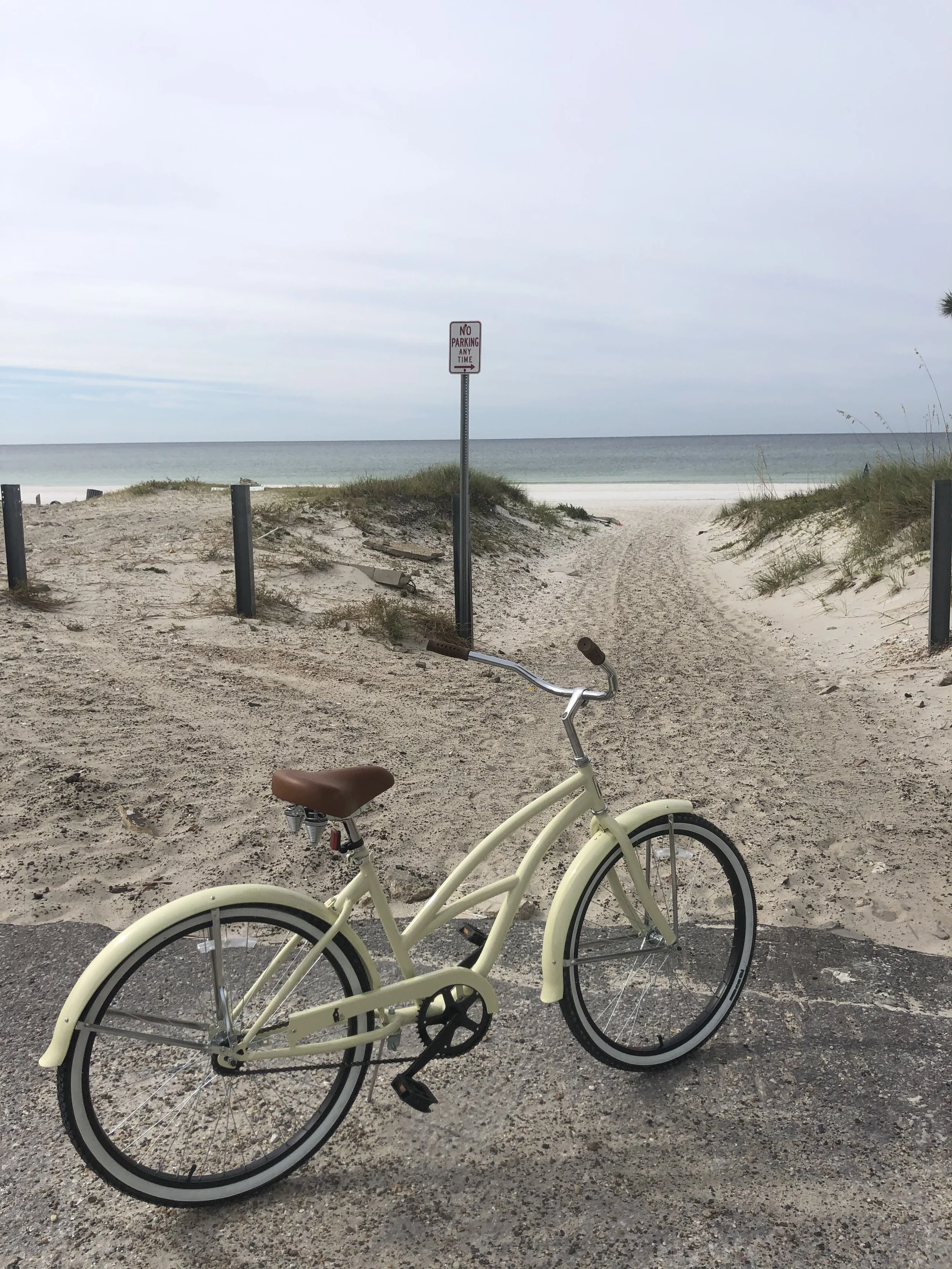 Rental bike parked at the edge of a sandy beach path, offering direct access to the shoreline in Panama City Beach.