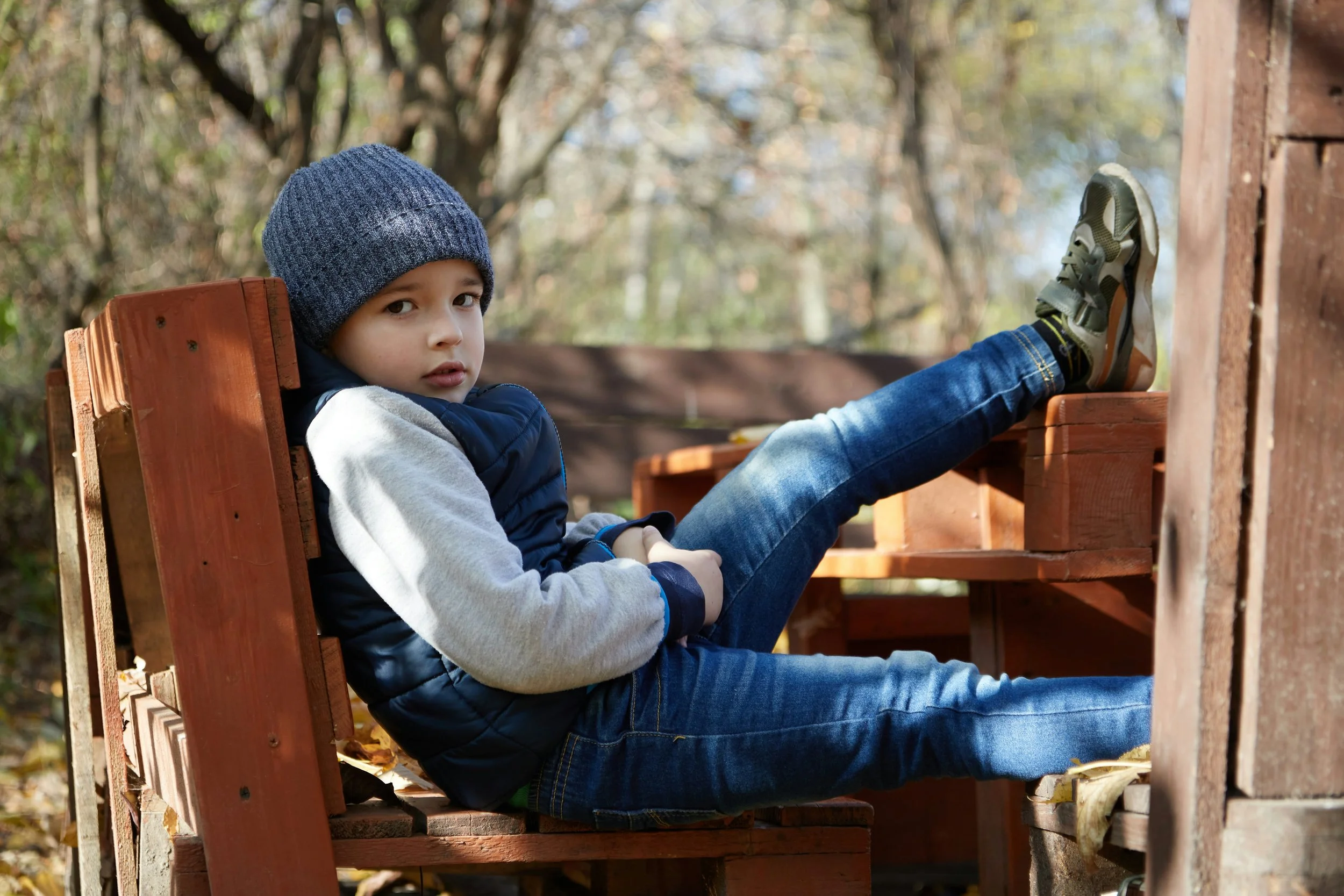 little boy relaxing on porch outside.
