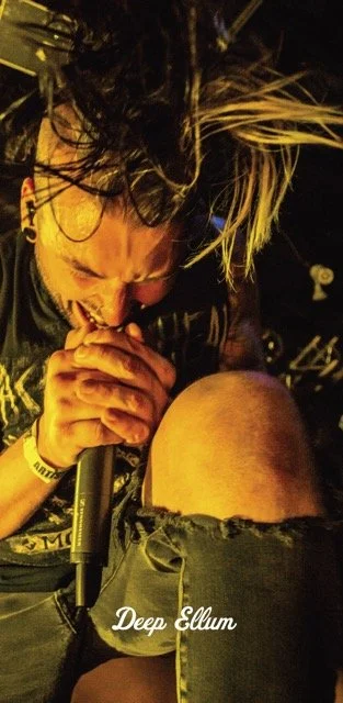 Alt="Streetlight pole banners in Deep Ellum featuring the Live Music Lens campaign highlighting local Dallas music and photography."