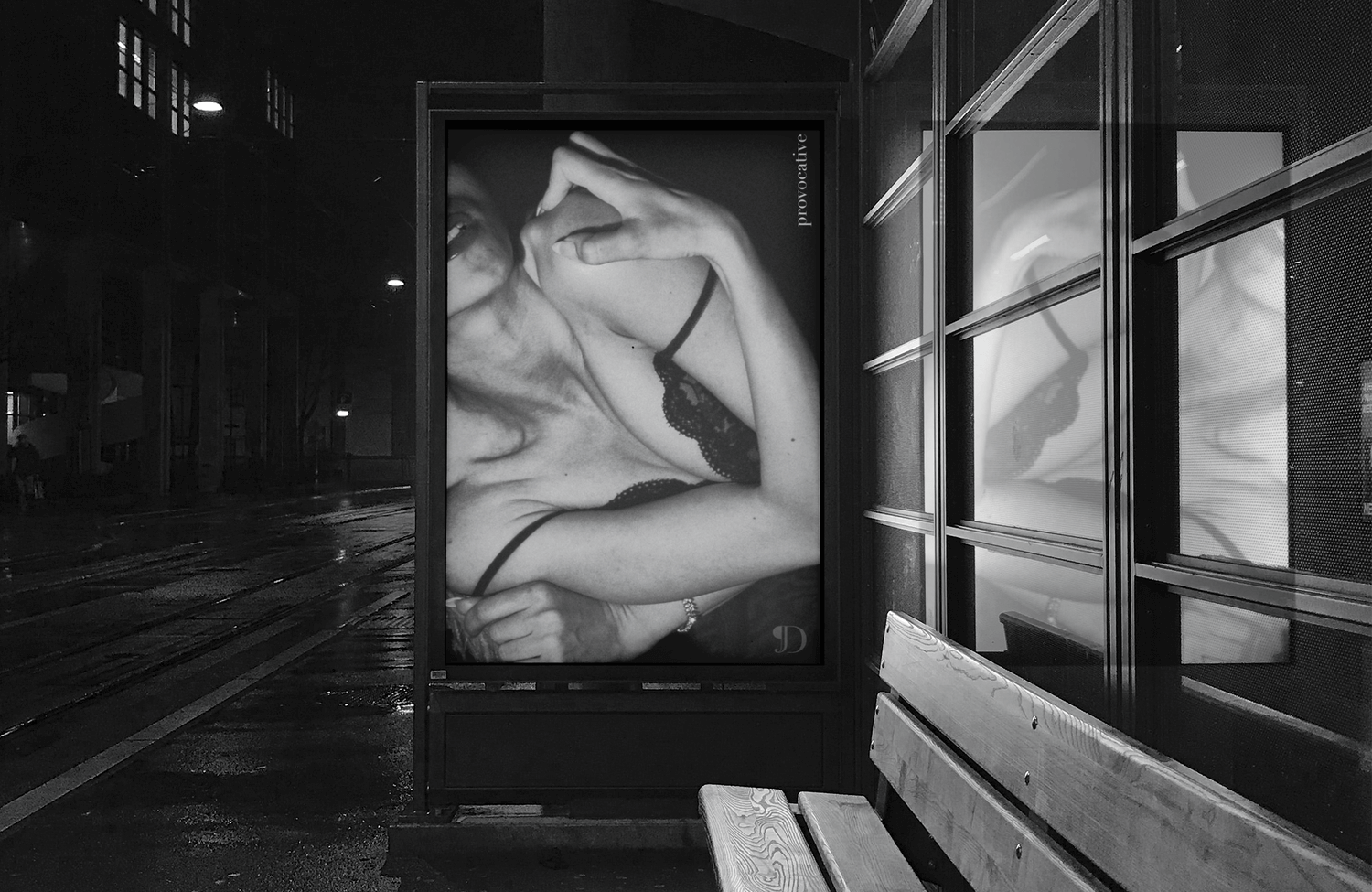 a bus stop displaying a cropped poster of a woman in lingerie