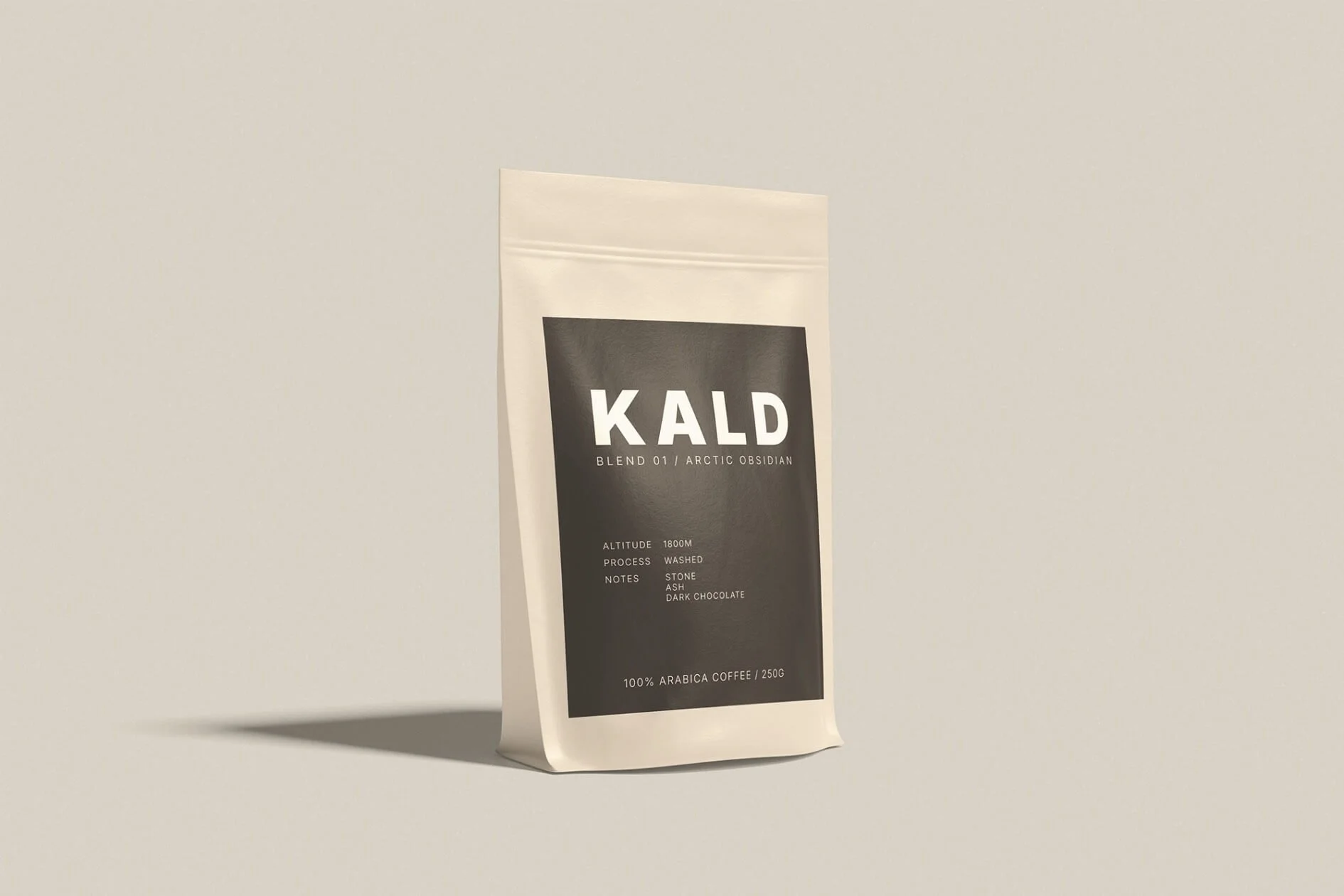 A beige package of KALD Arctic Obsidian coffee standing on a flat surface against a light background.