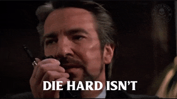 A gif from the movie "Die Hard." Hans Gruber is saying "Die Hard isn't a Christmas Movie," then John McClane says "Yes it Yippee-Ki-Yay Is!"