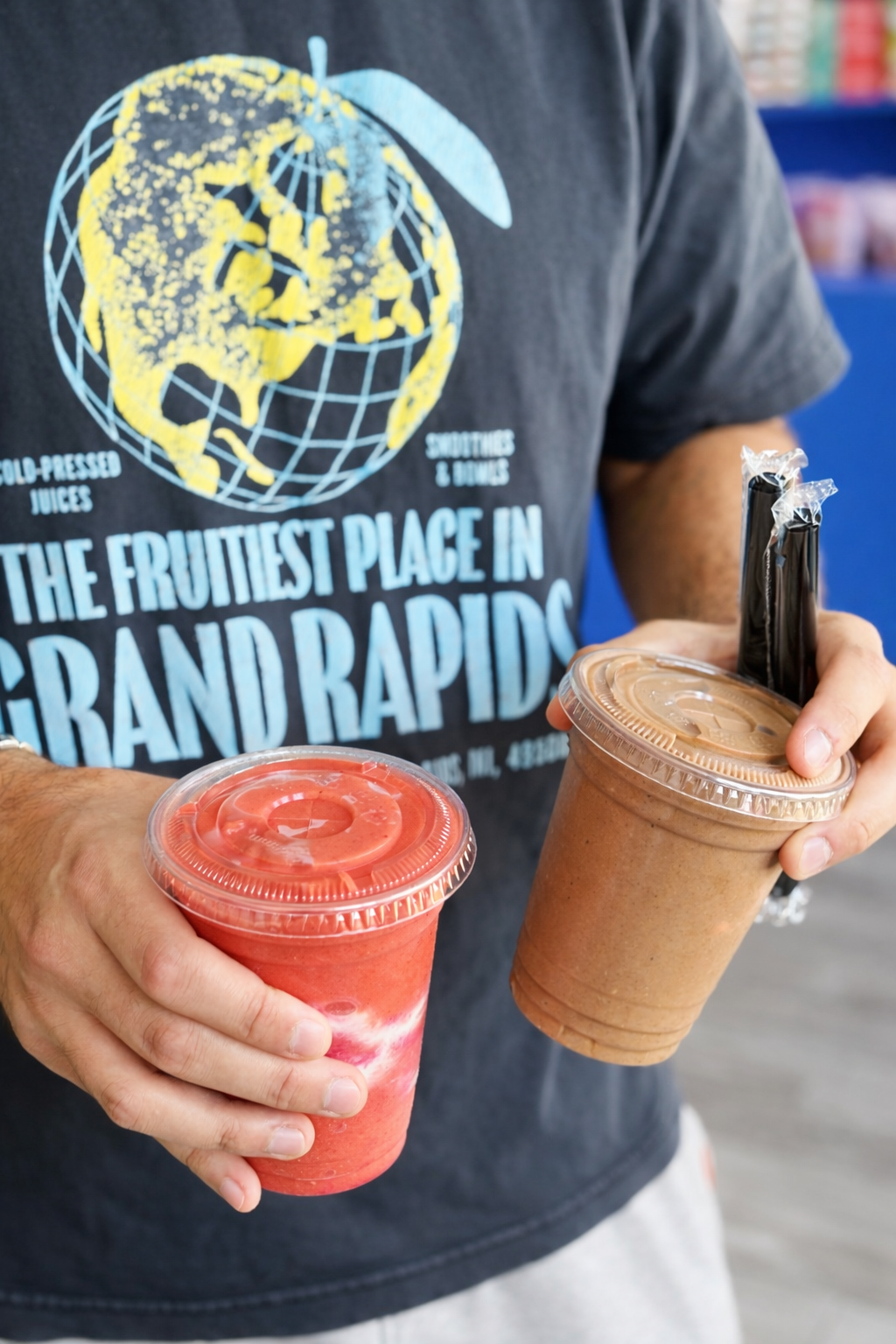 Man holding two healthy smoothies in grand rapids from good judys