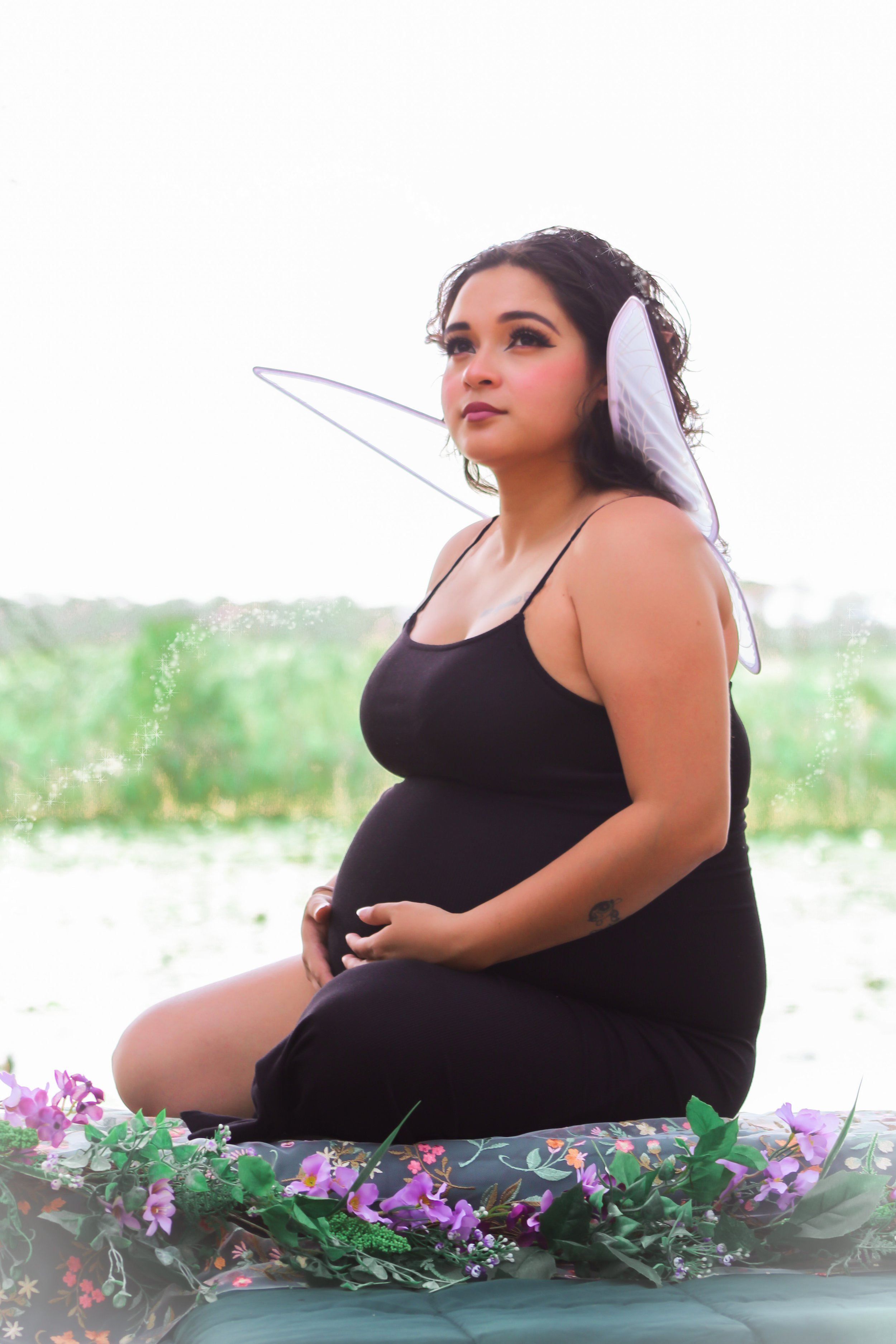 Creative maternity photography featuring floral styling, fairy wings, and fine art portraiture.