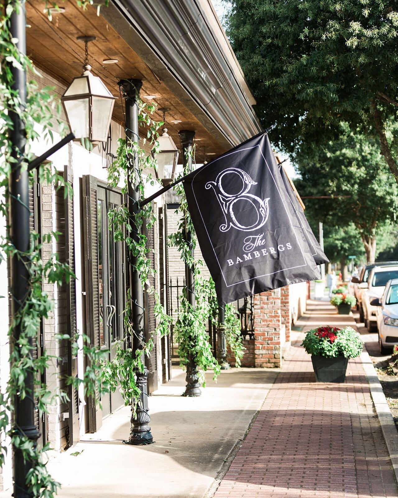 Creating your own flags to brand the front of your reception entrance is always a yes in our book! We love how @wildflowers_fairhope greener the front post making this entrance extra inviting !