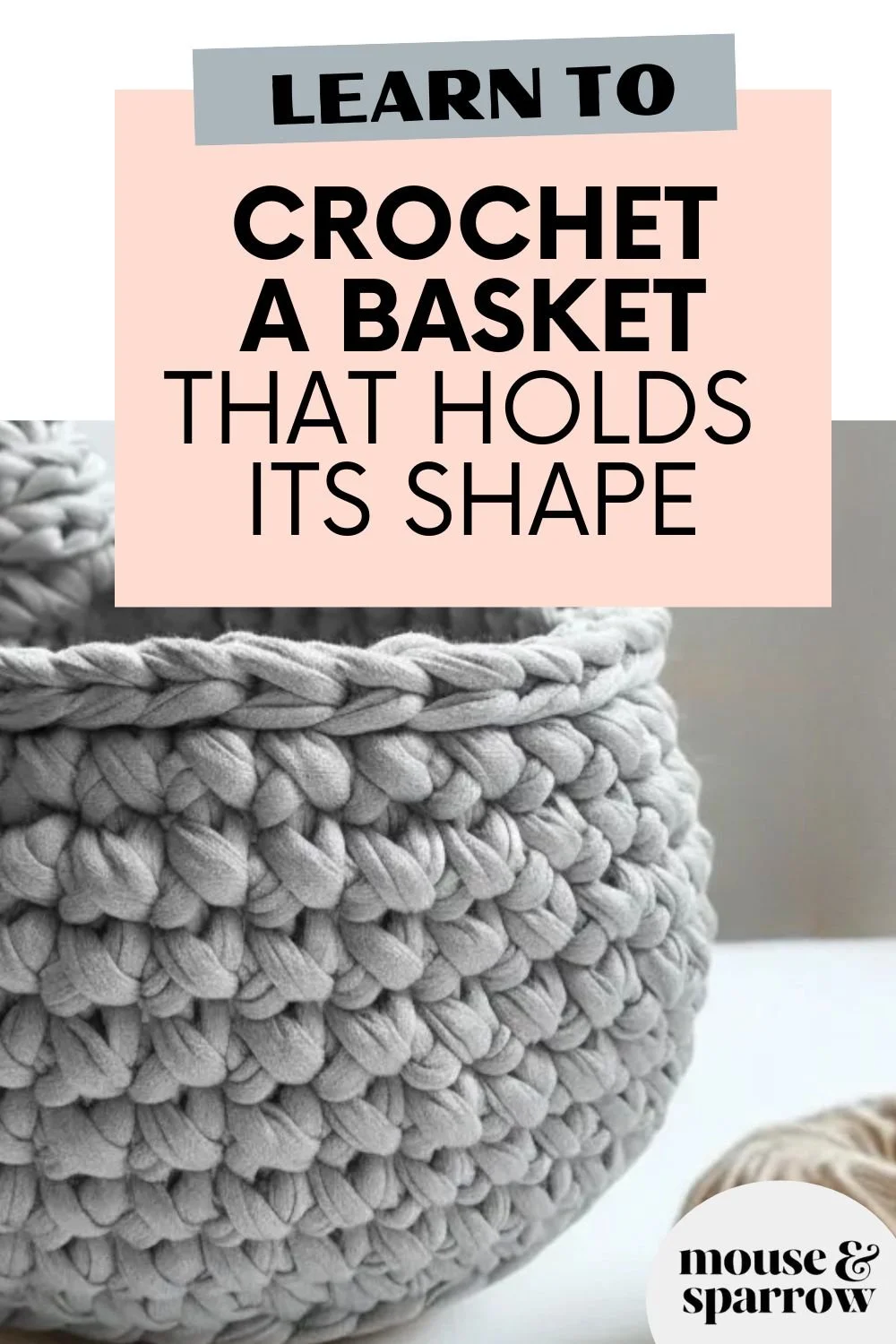 Handmade crochet storage basket in neutral cotton yarn used for home organisation on a shelf