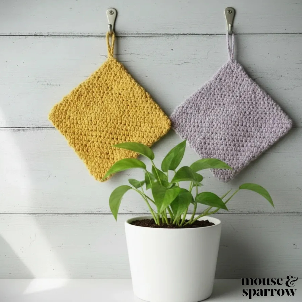double thick crochet potholders hanging on a hook in a kitchen