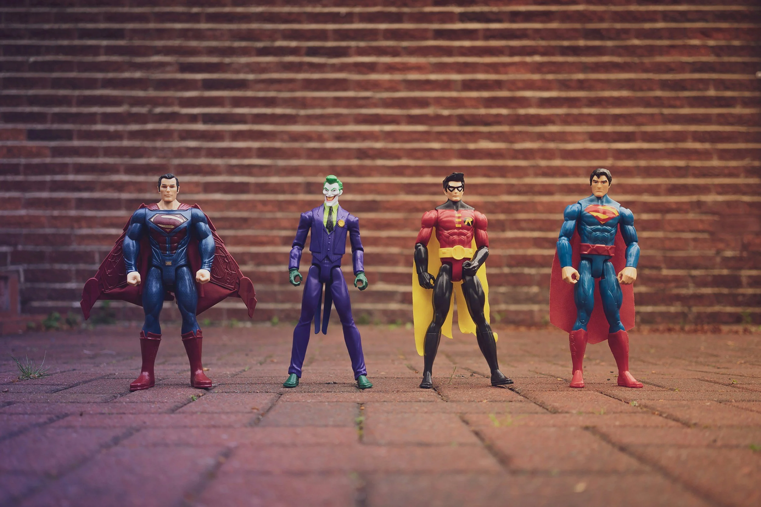Four protagonists standing in front of a brick wall
