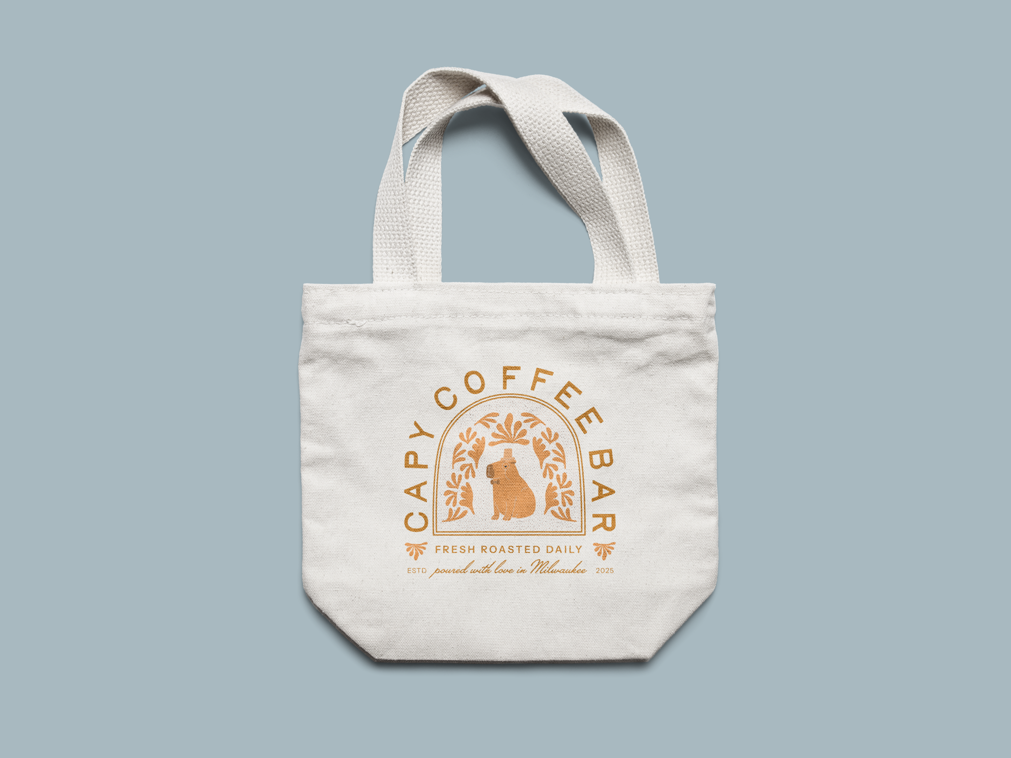 White tote bag with a coffee shop logo featuring a bear and decorative leaves, and text that reads "Happy Coffee Bar" and "Fresh Roasted Daily" on a light blue background.