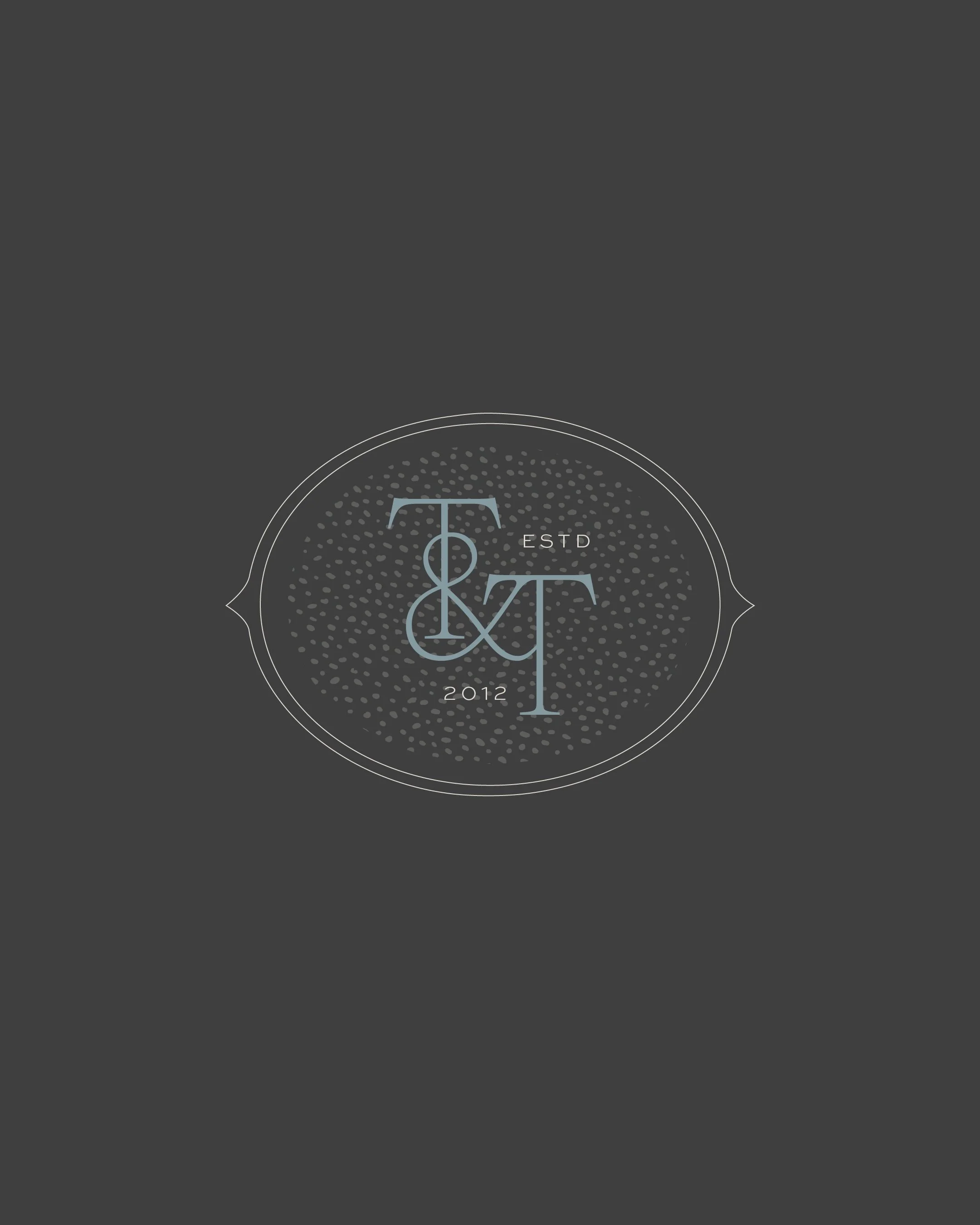 Logo with initials T and T, ESTD 2012, on a dark gray background.