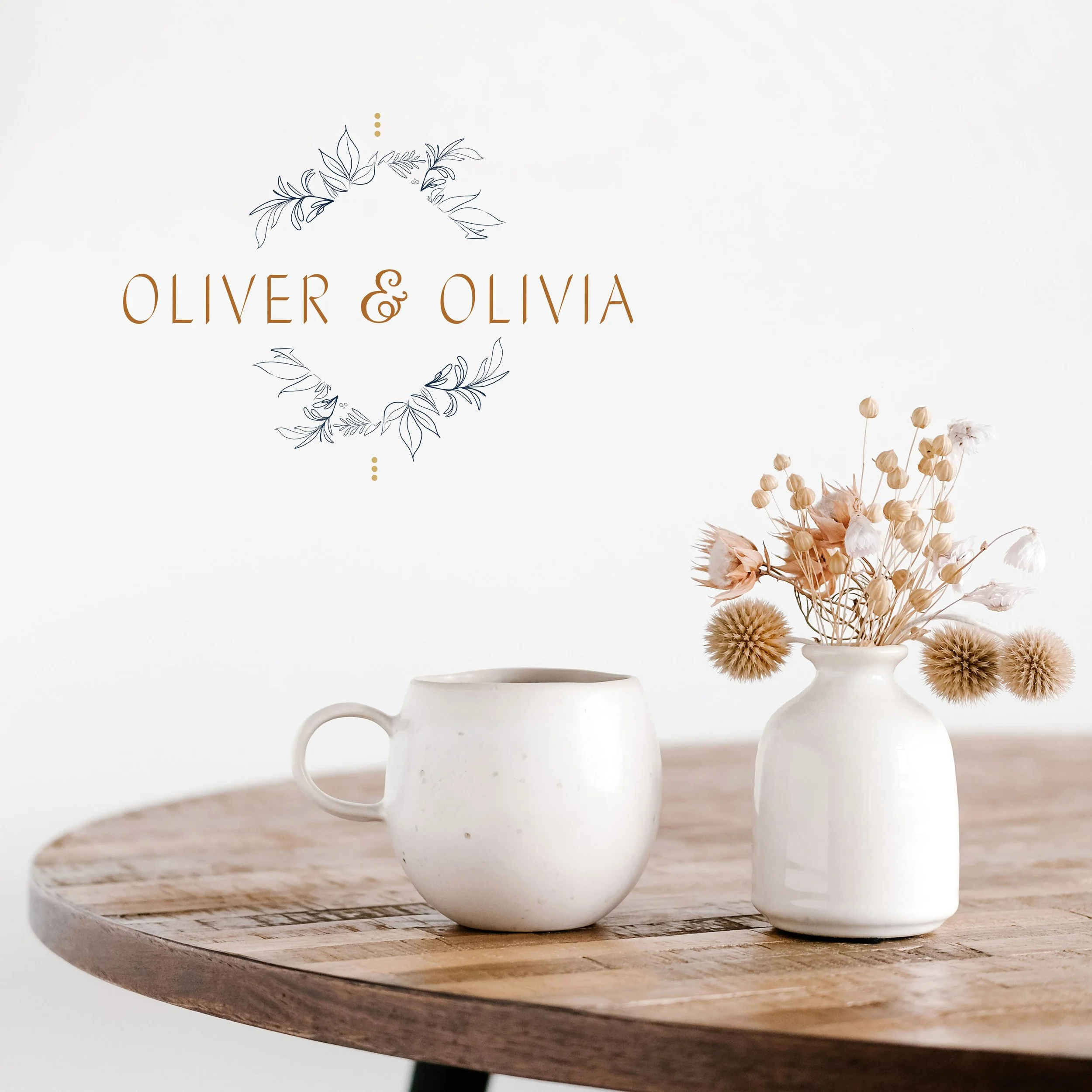 A white cup and a white vase filled with dried flowers on a wooden table, with text "Oliver & Olivia" and a decorative leaf graphic on a white background.
