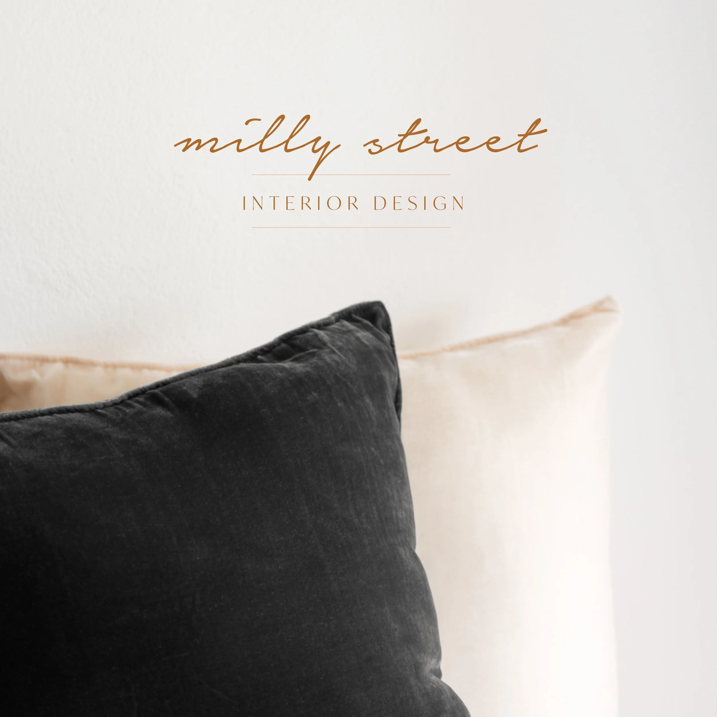 Close-up of a black velvet pillow on a beige upholstered headboard with the text 'milly street INTERIOR DESIGN' overlayed, likely a design or interior decor branding image.