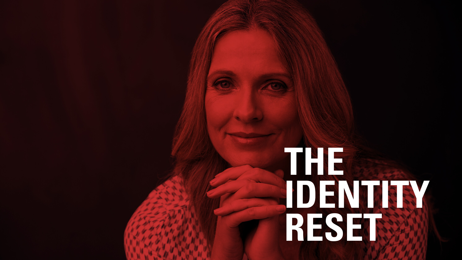 Woman with long hair, hands clasped near chin, in red-toned lighting. "THE IDENTITY RESET" text on the right.