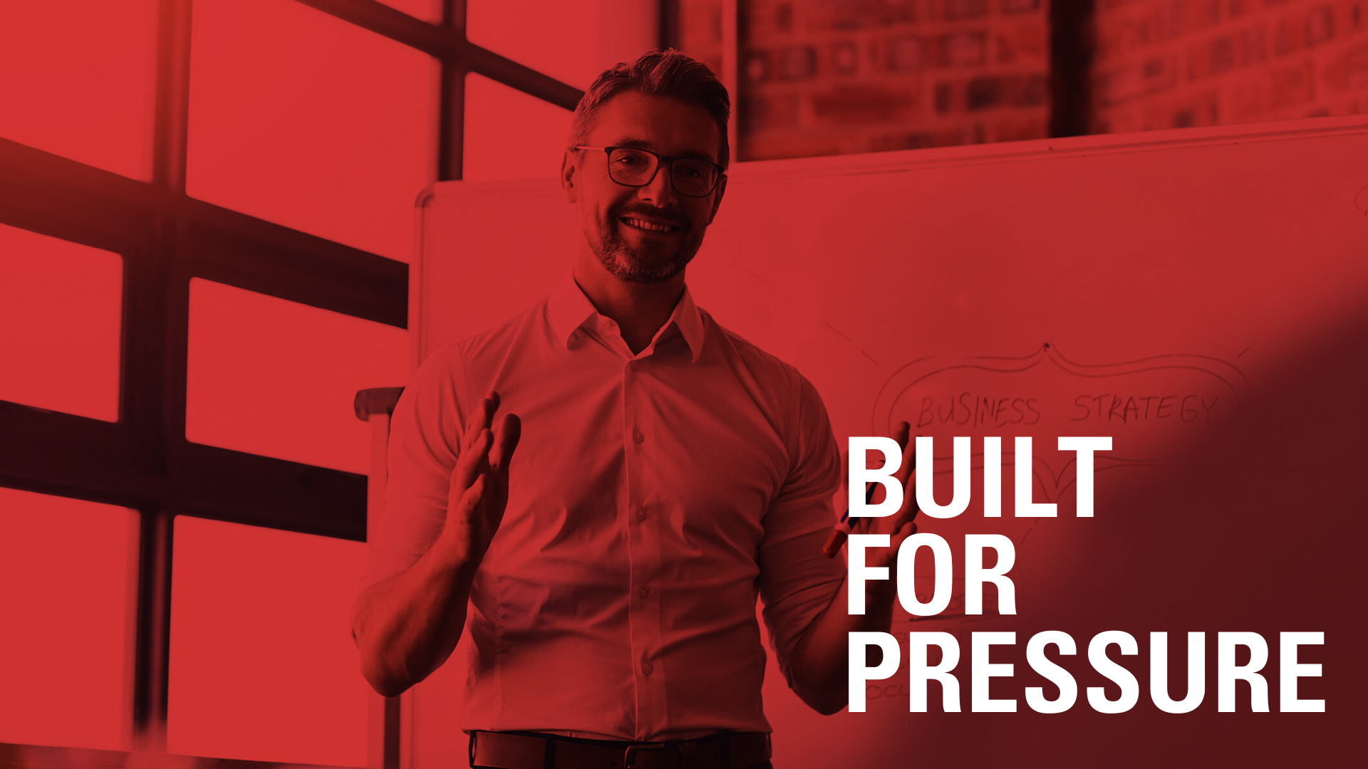 Man in a business setting giving a presentation with the text "Built for Pressure" overlaid in white.