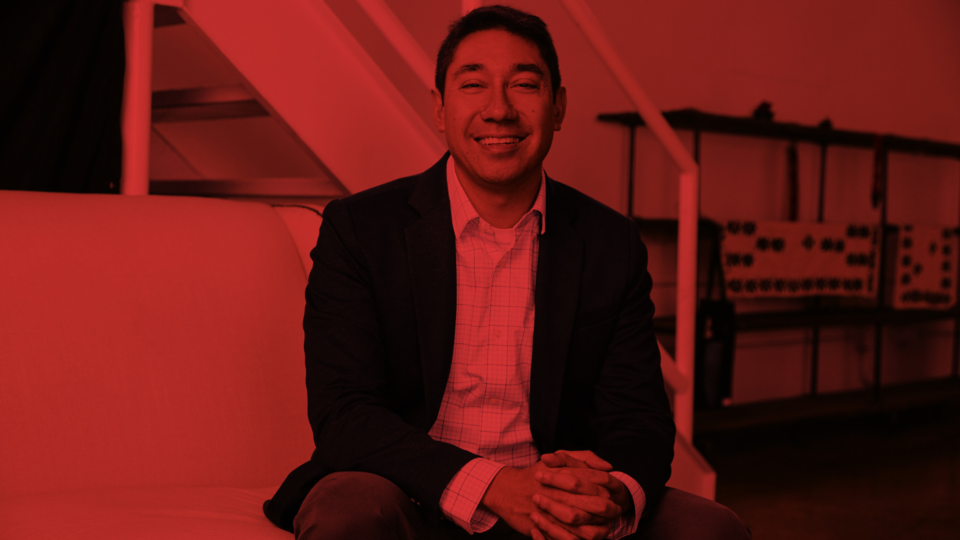 Man sitting on a couch and smiling.