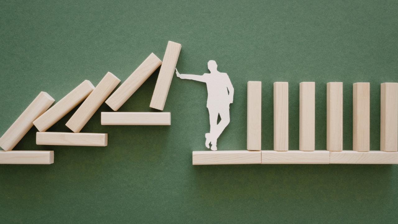 Porfessional looking wooden man on shelf stopping blocks from falling on him
