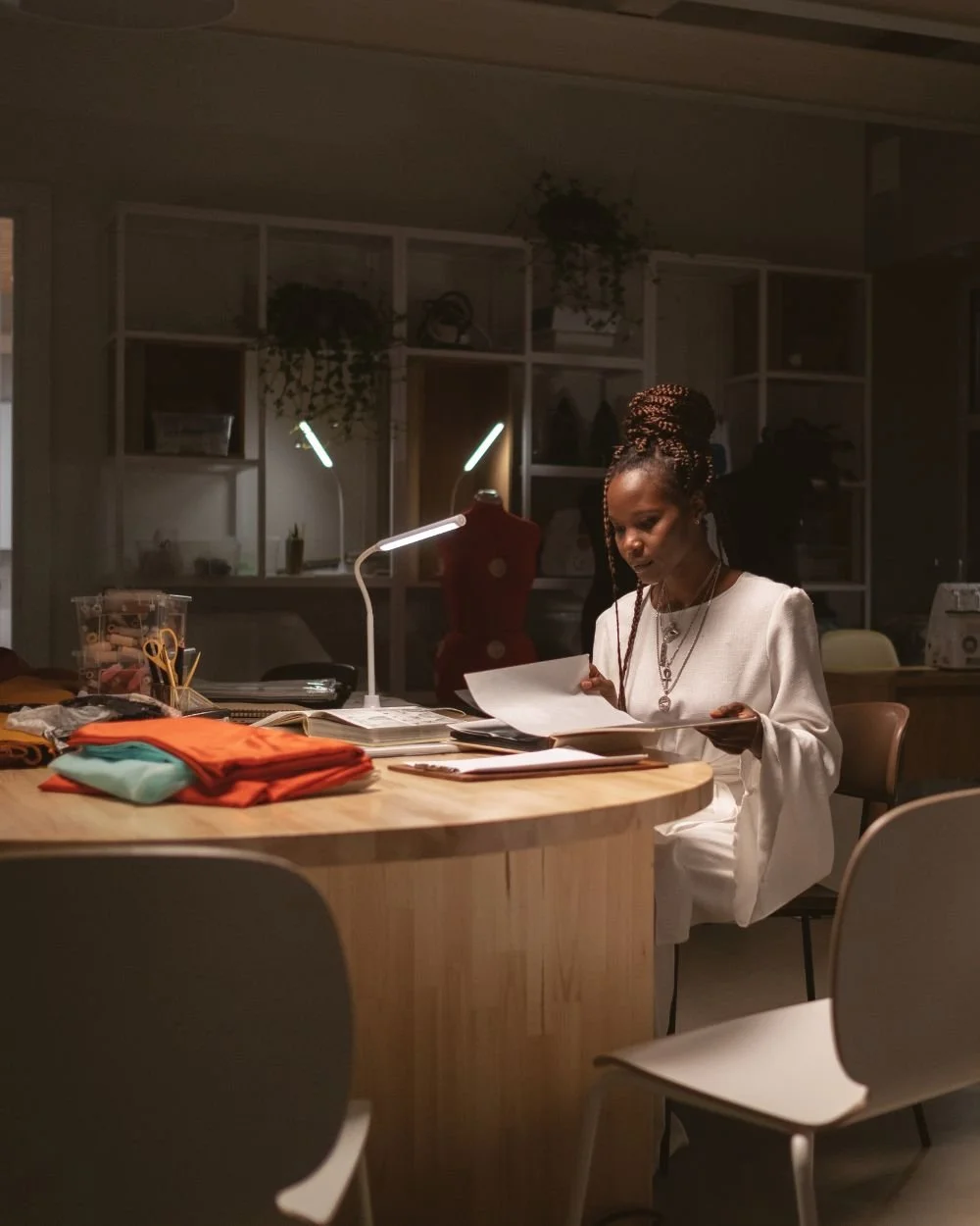 Woman working late at a detailed craft desk, representing the drive to get everything exactly right