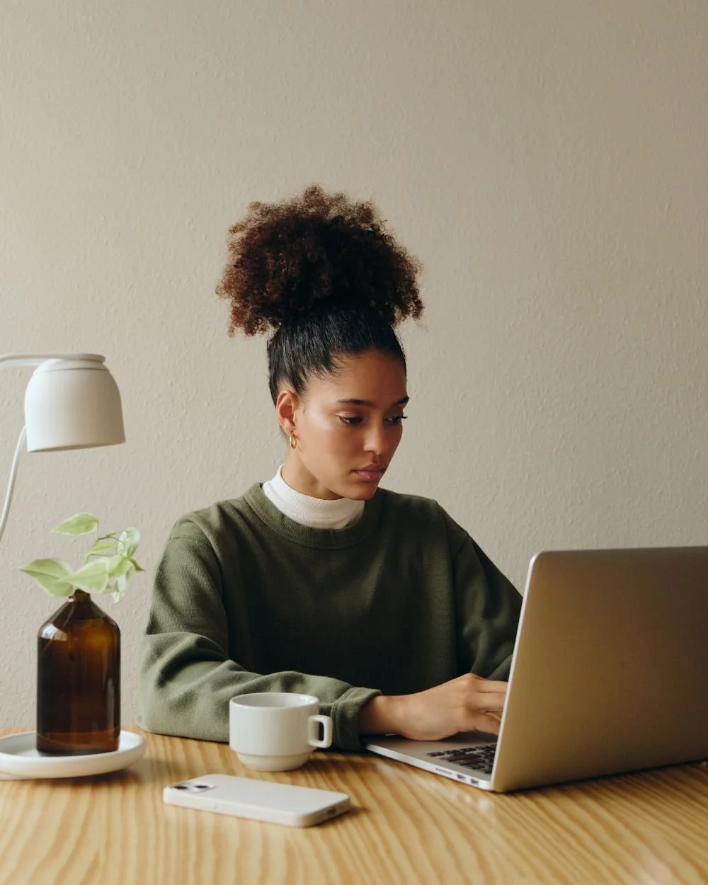 Focused woman working on a laptop, representing the disconnect between outward competence and inner self-criticism